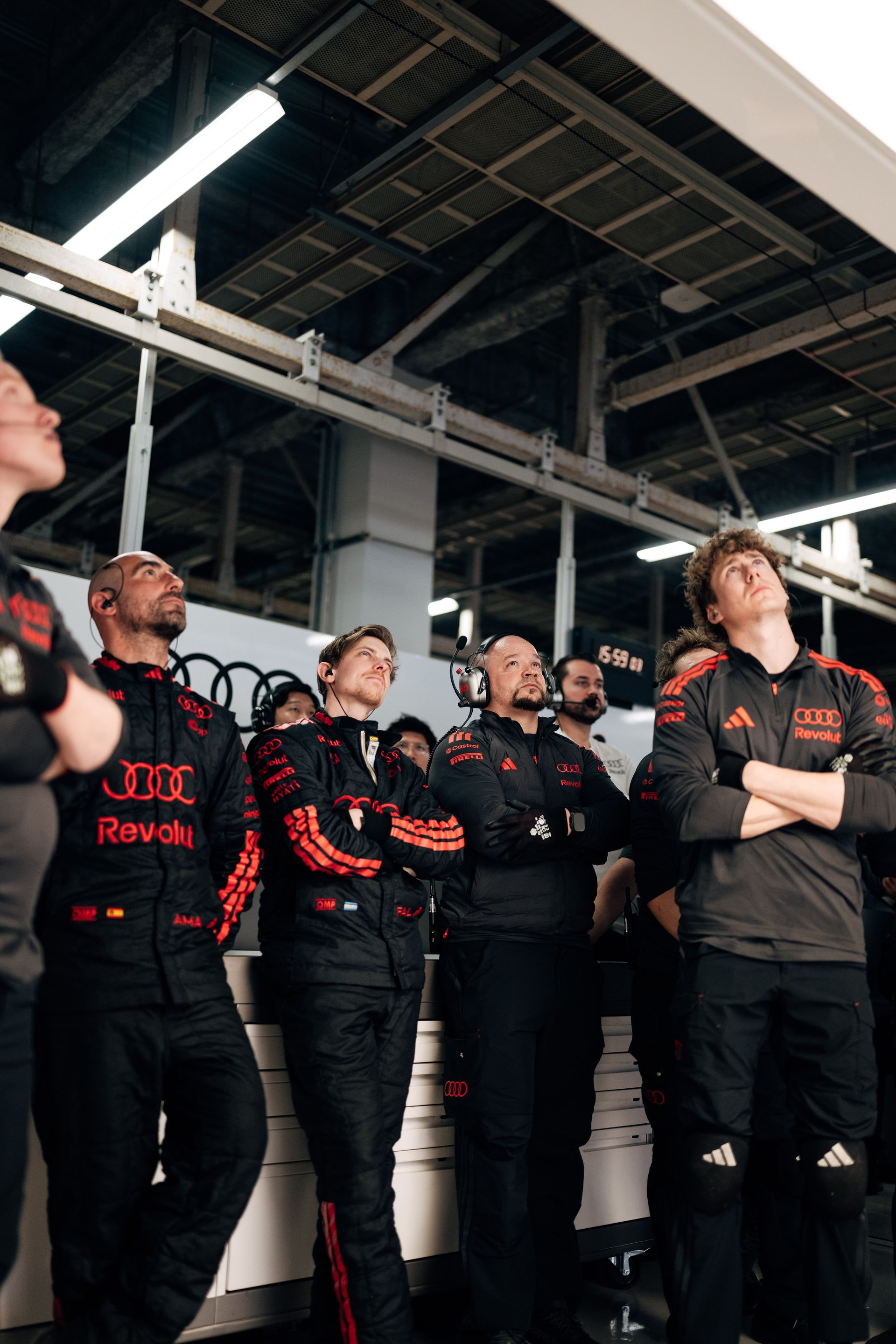 Audi Revolut F1® Team crew members stand together in the garage watching the monitors during the Suzuka weekend.