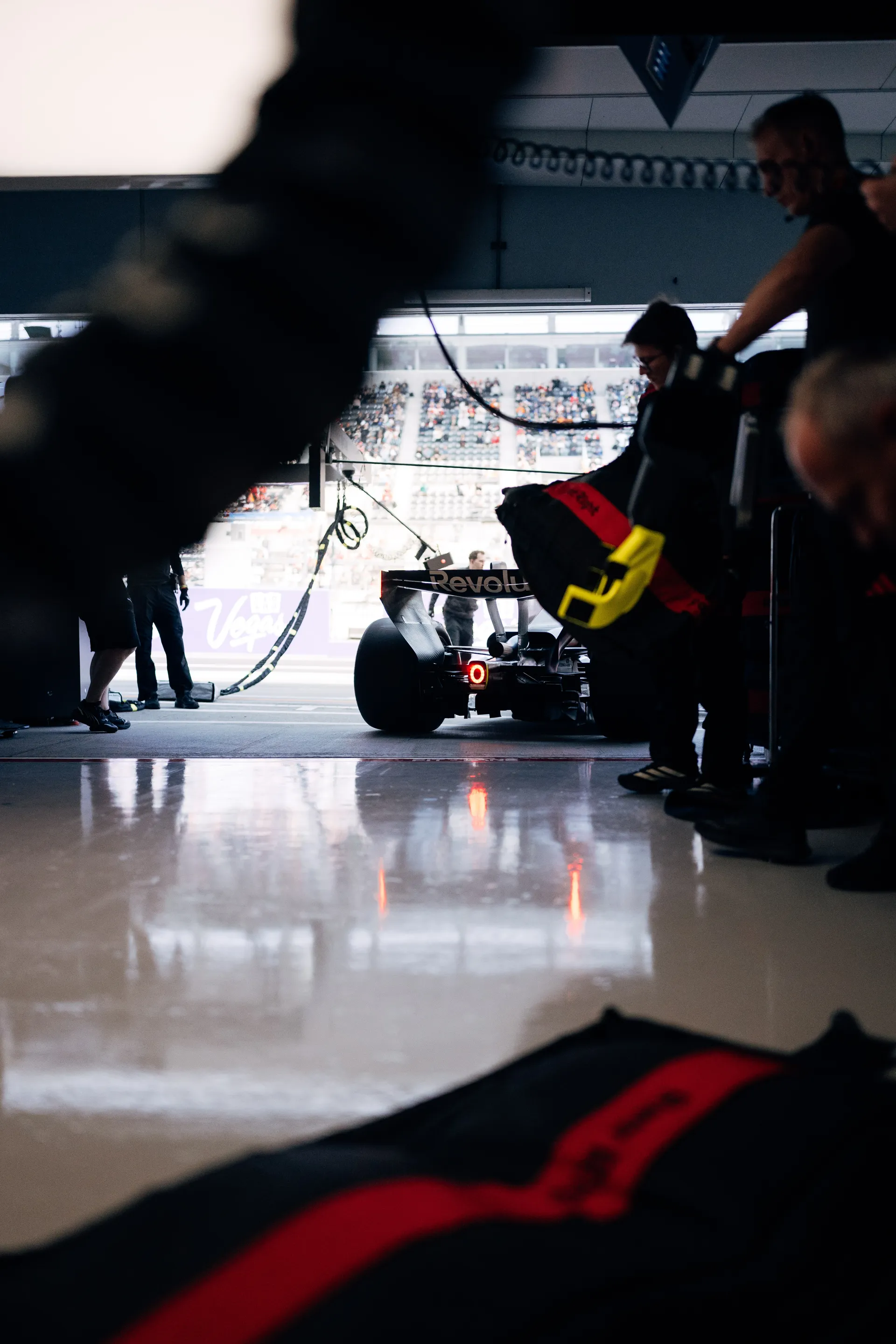 Low angle garage view of the Audi Revolut F1® Team car at the exit as crew members prepare for release to the pit lane.
