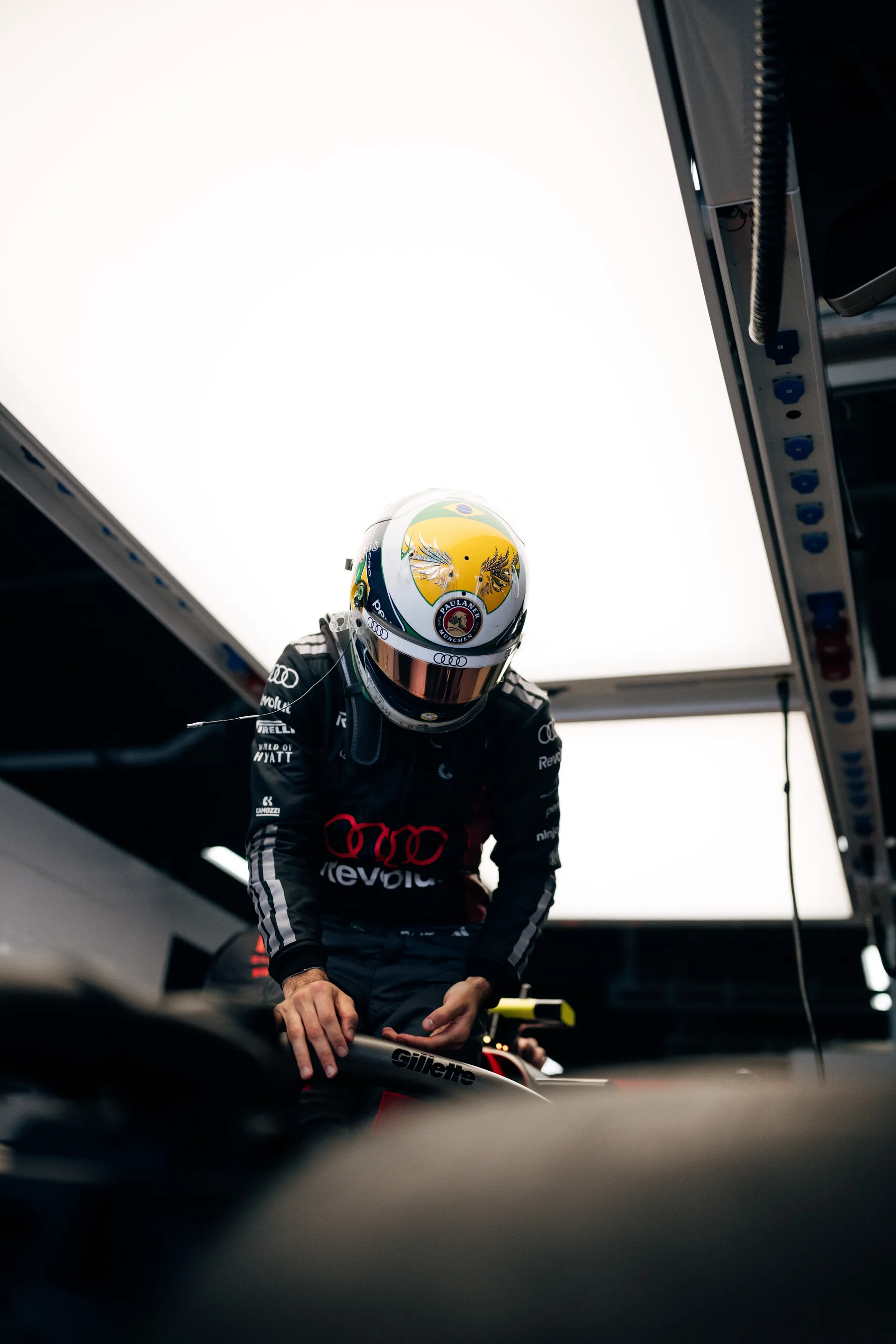 Gabriel Bortoleto stands over the car in the garage wearing full race gear before heading out.