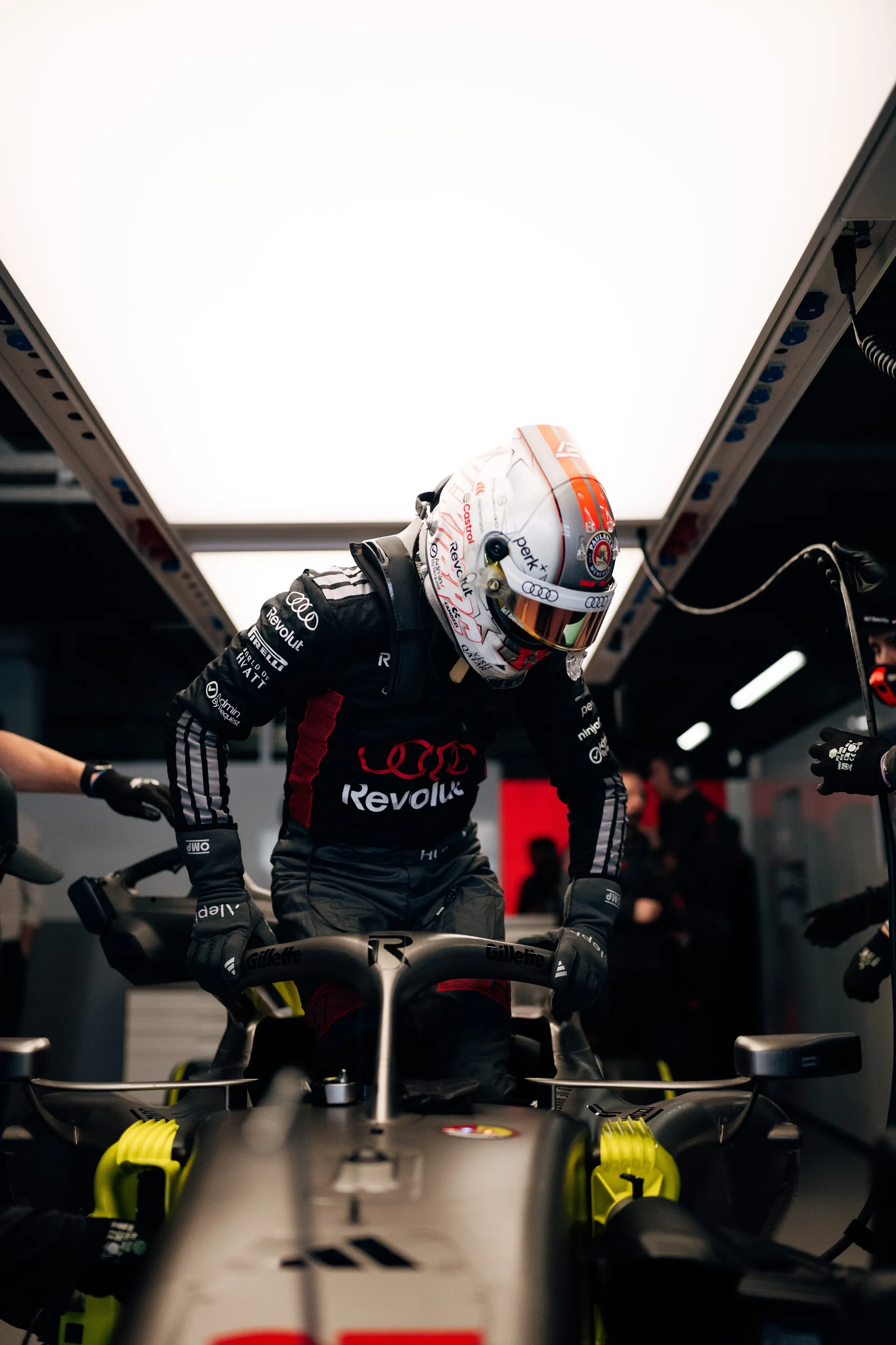 Nico Hulkenberg climbs into the car in the Audi Revolut F1® Team garage.