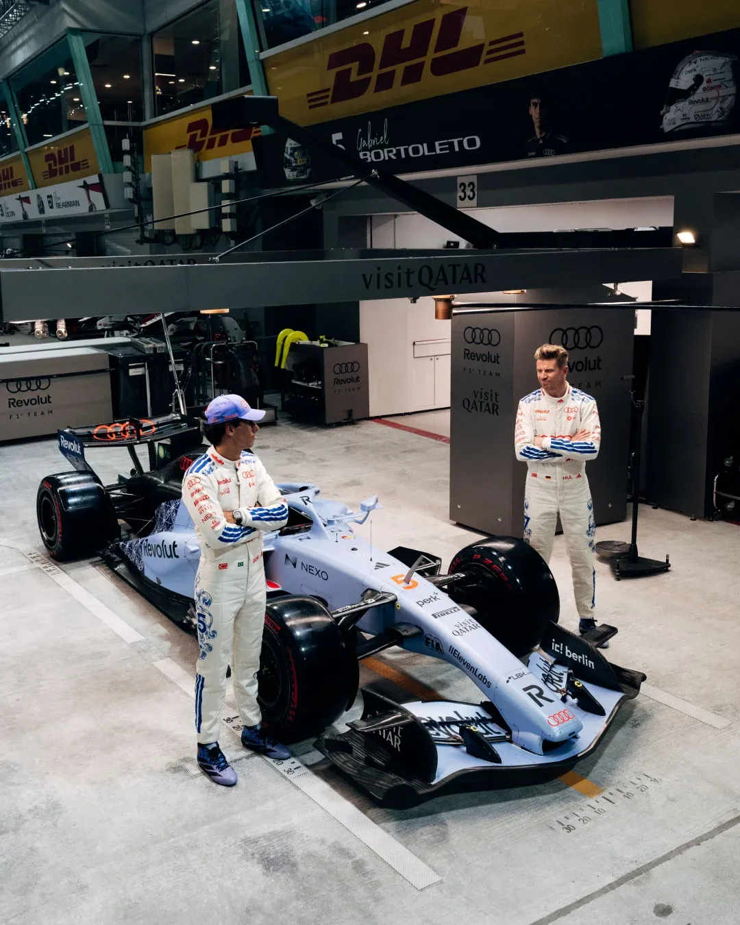 Audi Revolut F1® Team drivers Gabriel Bortoleto and Nico Hulkenberg with the F1 car in the Singapore GP garage