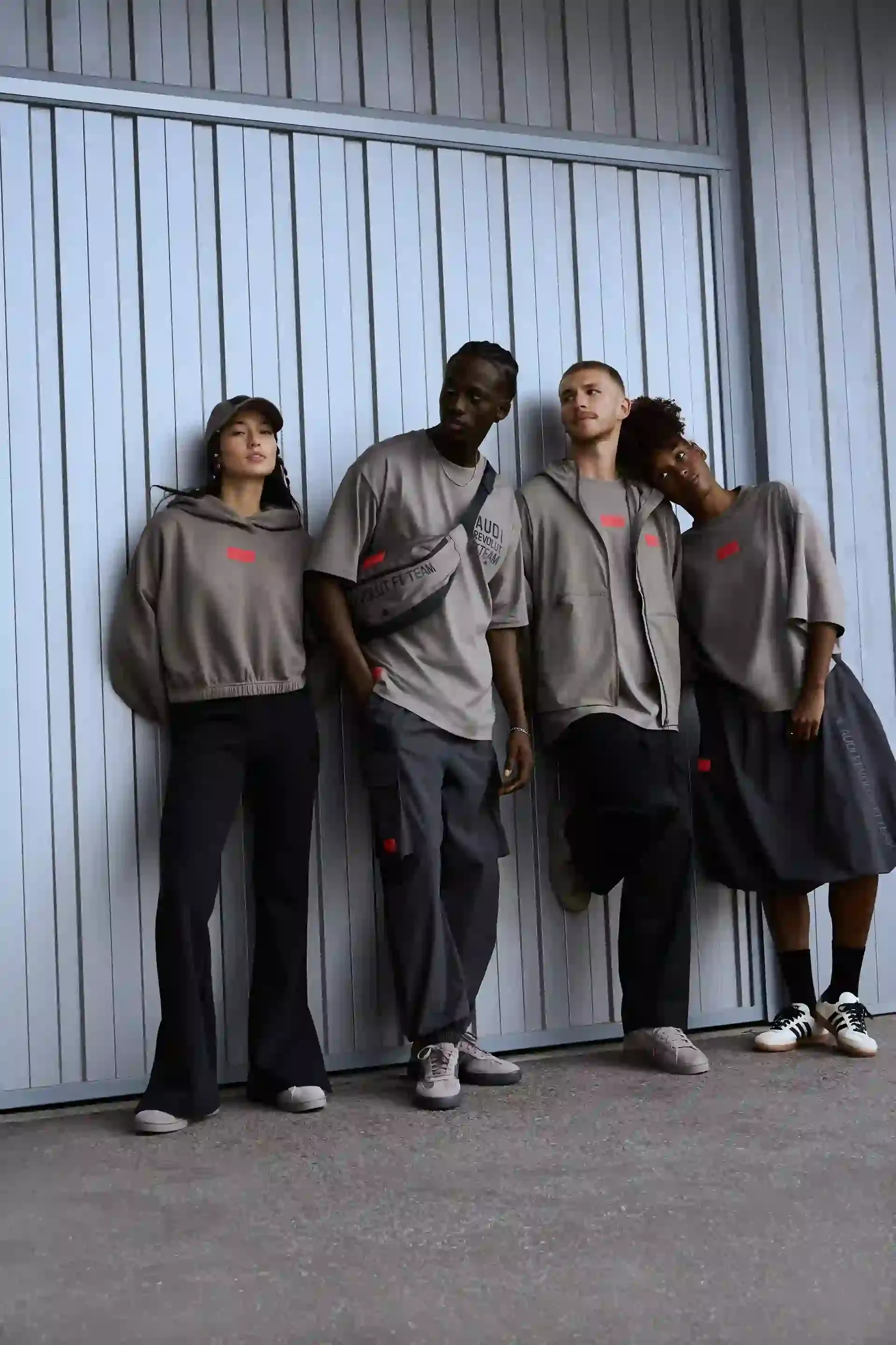 Group of young people in streetwear leaning against the wall adidas fanwear summer season 26