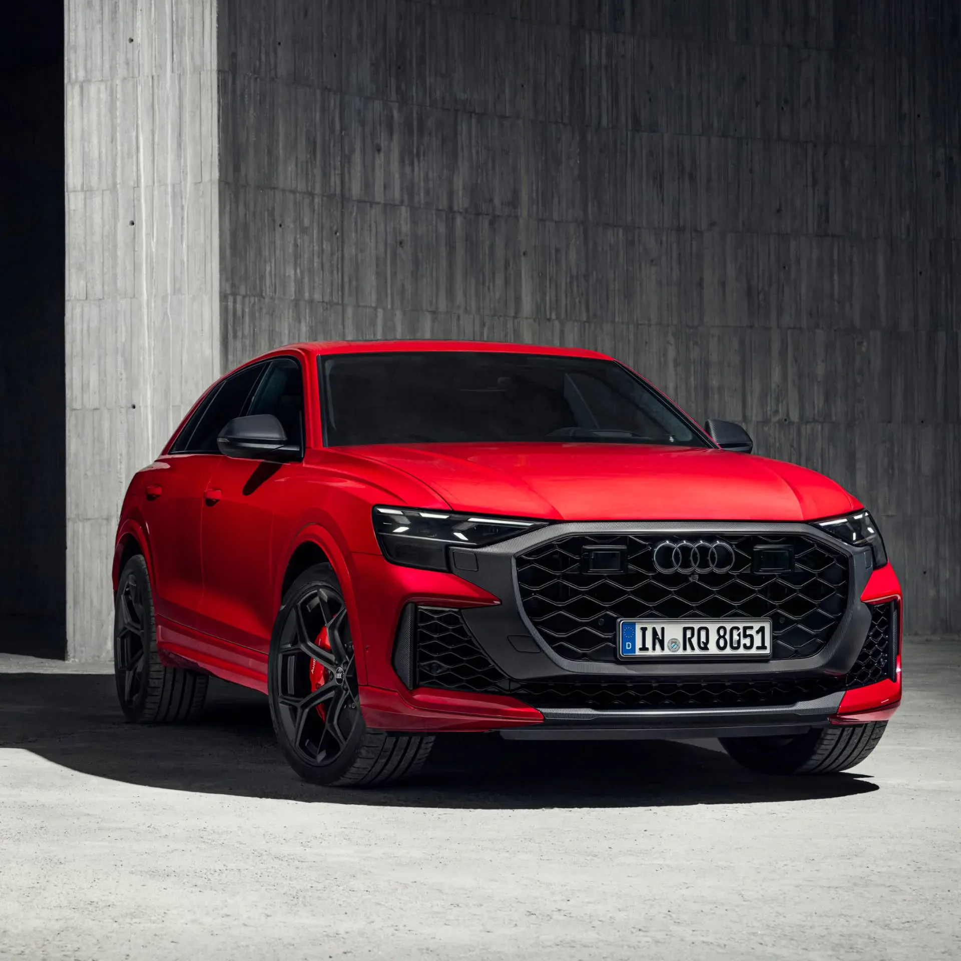Red Audi Car standing in front of a concrete wall 