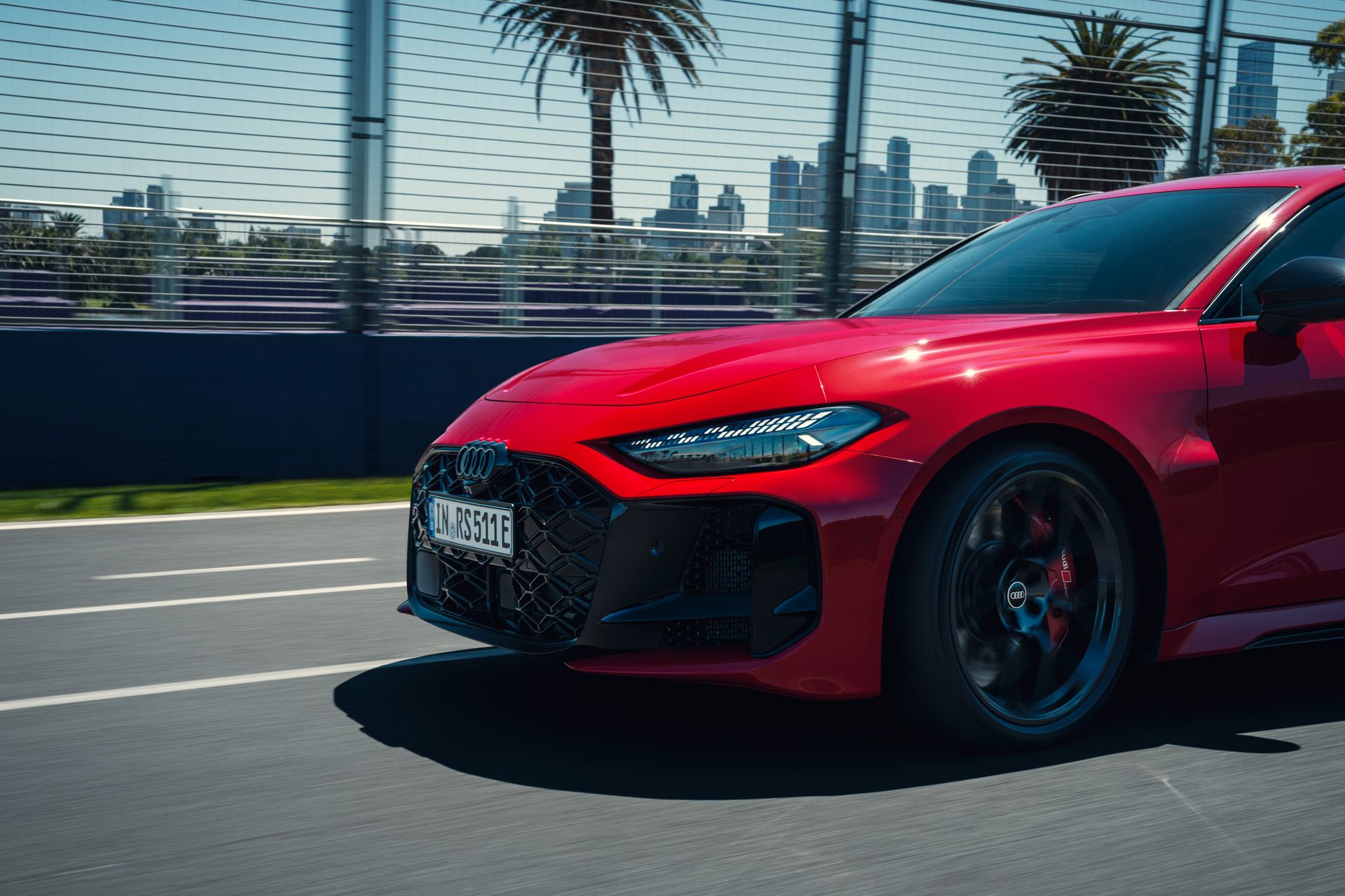 Audi RS5 ReconnaissanceMission car front pacing on track with the skyline from Melbourne in the background
