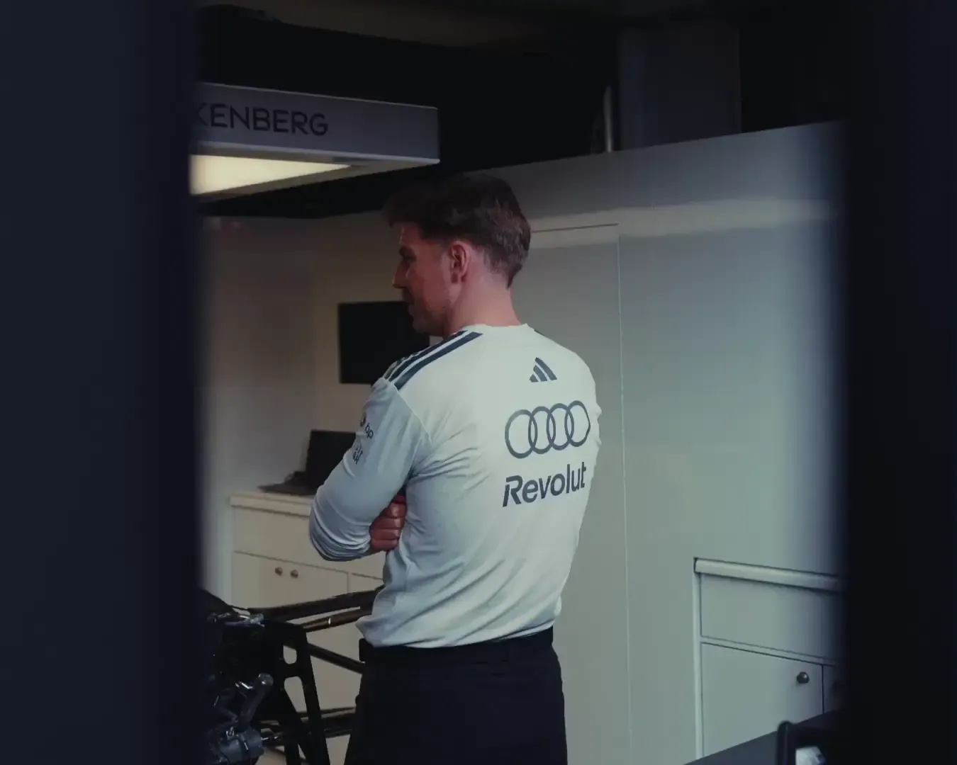 A team member is standing in the pit talking to others