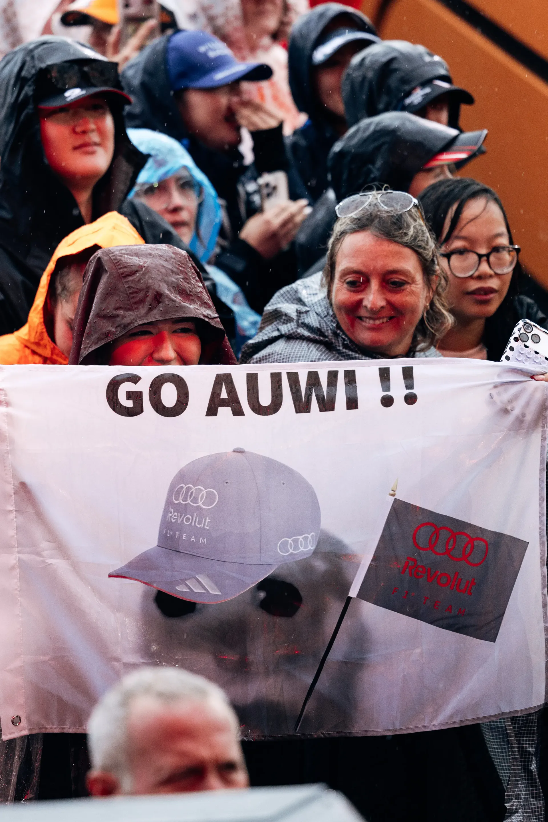 Audi Revolut F1 Team supporters holding "GO AUWI!!" banner in rain at Zandvoort