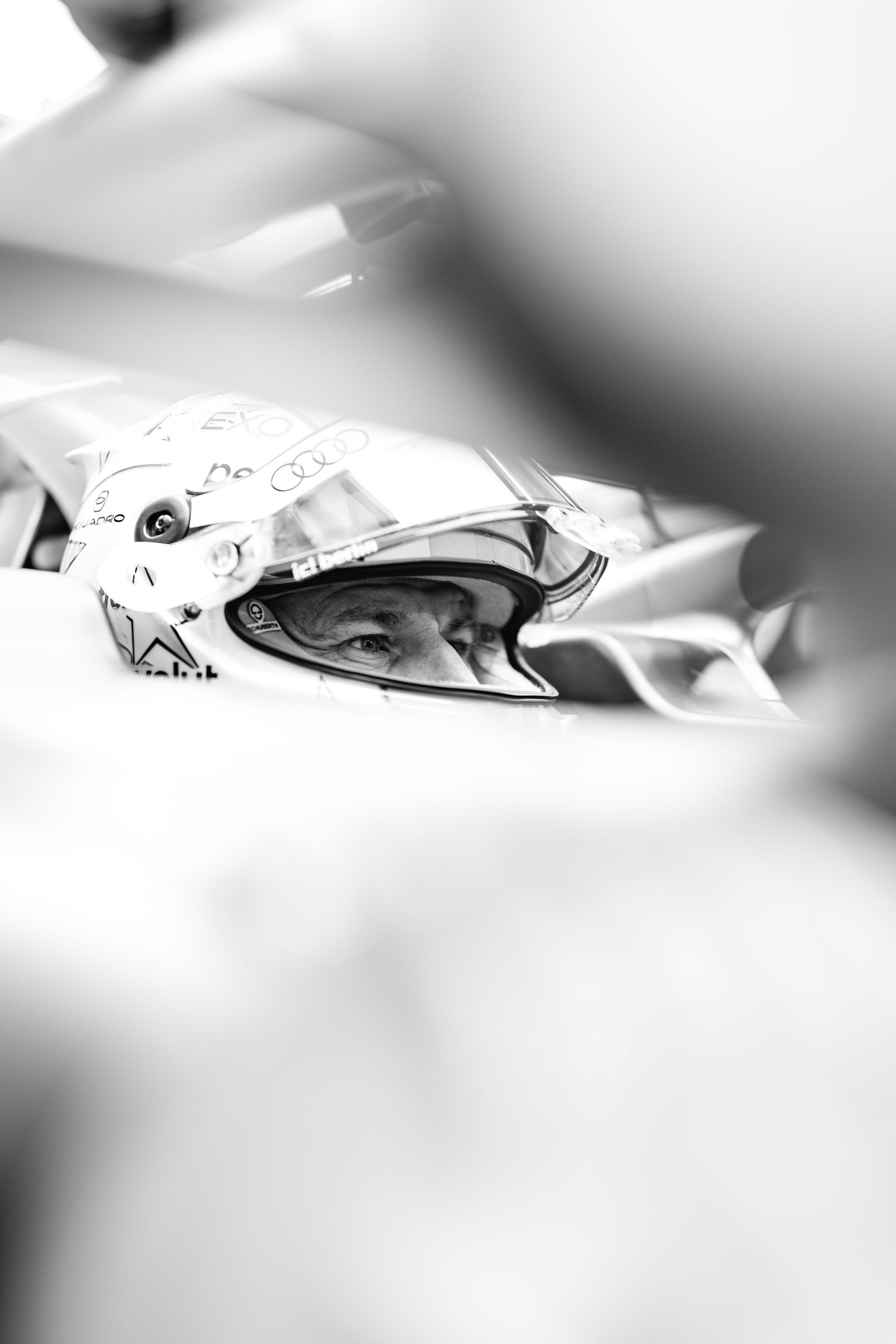 Black and white Close-up from Nico Hulkenberg in the car wearing a helmet