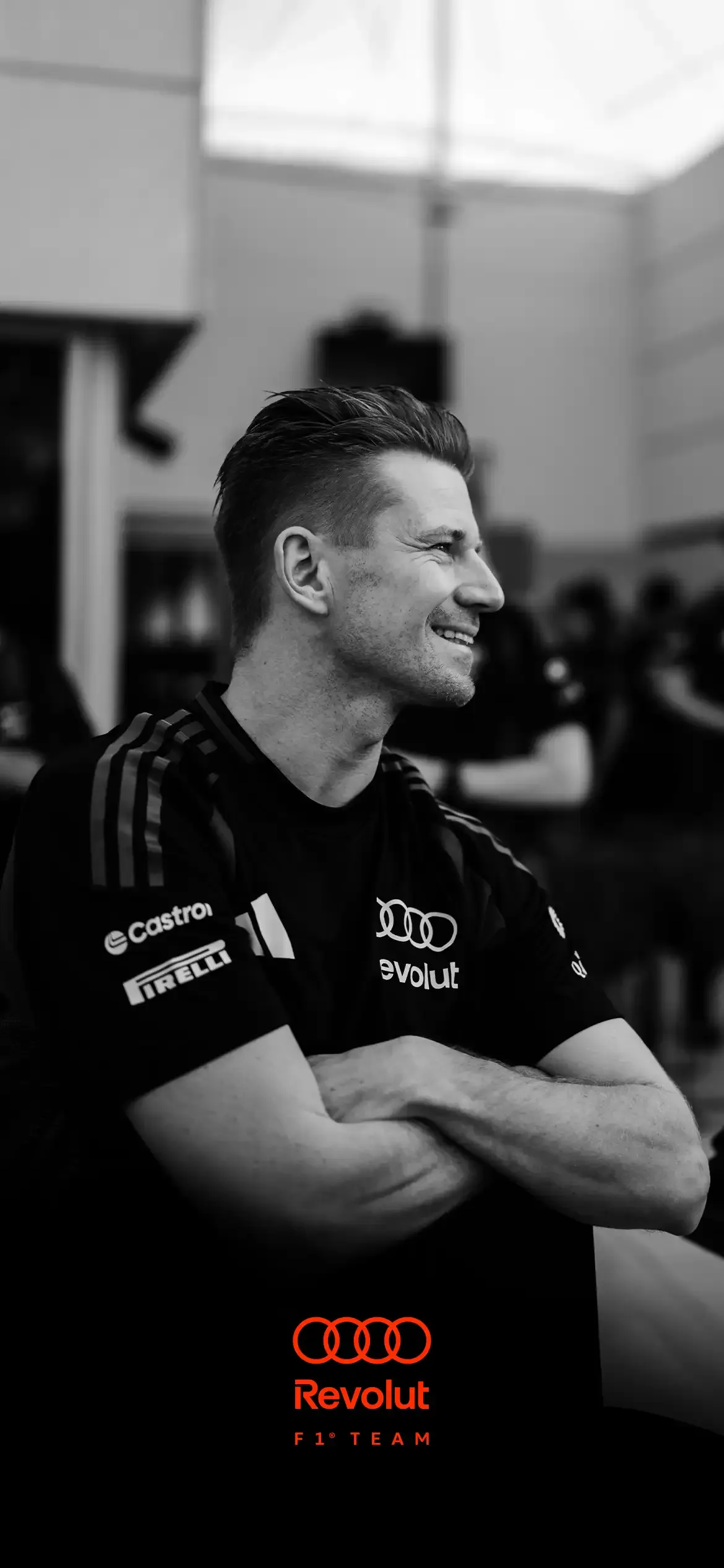 Image of AUDI REVOLUT F1® TEAM drive Nico Hulkenberg inside the garage at Bahrain Testweek wearing crew thirt with, black and white foto