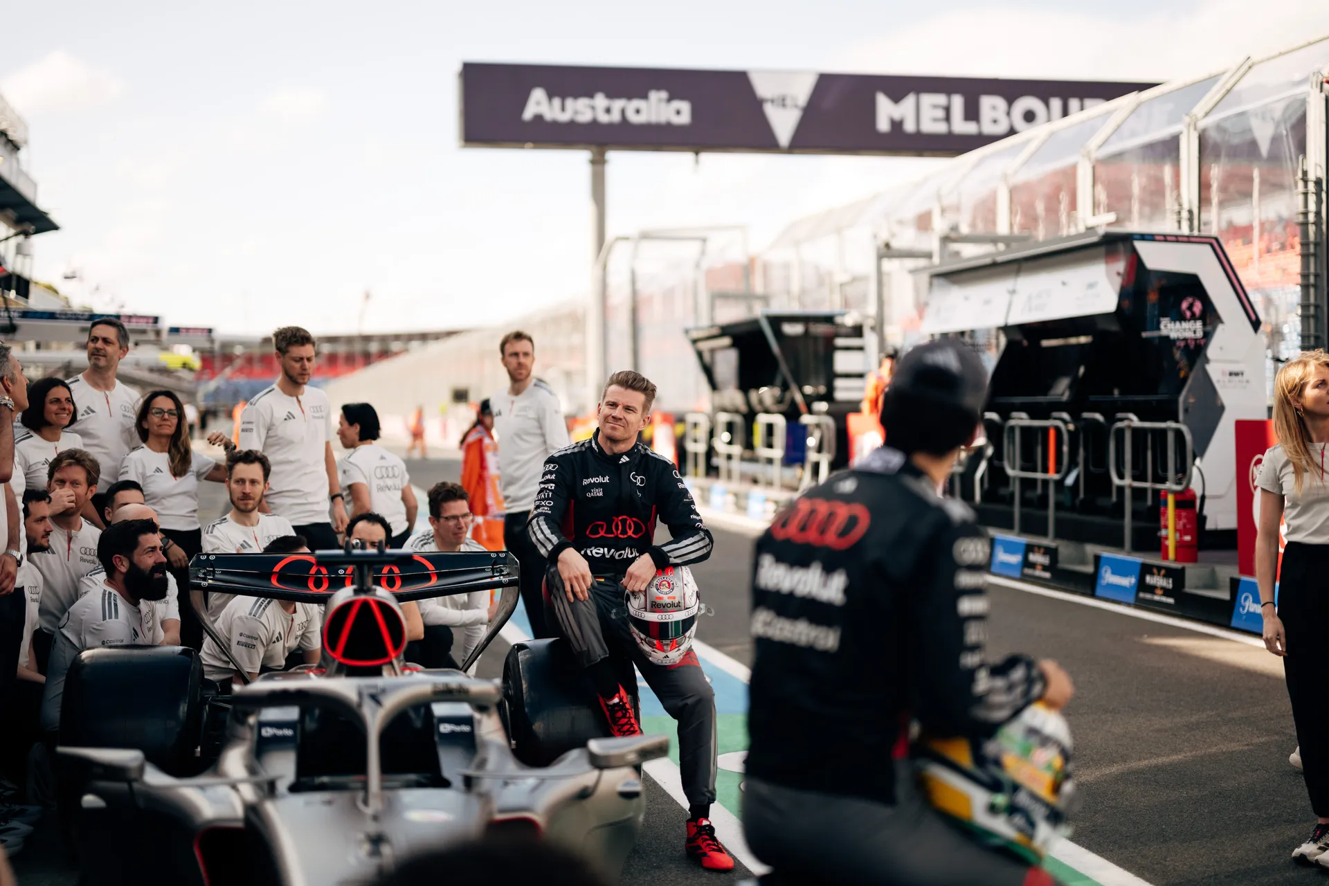 Audi Revolut F1® Team driver poses beside the Formula 1 car with helmet during a team photo on the Melbourne grid.