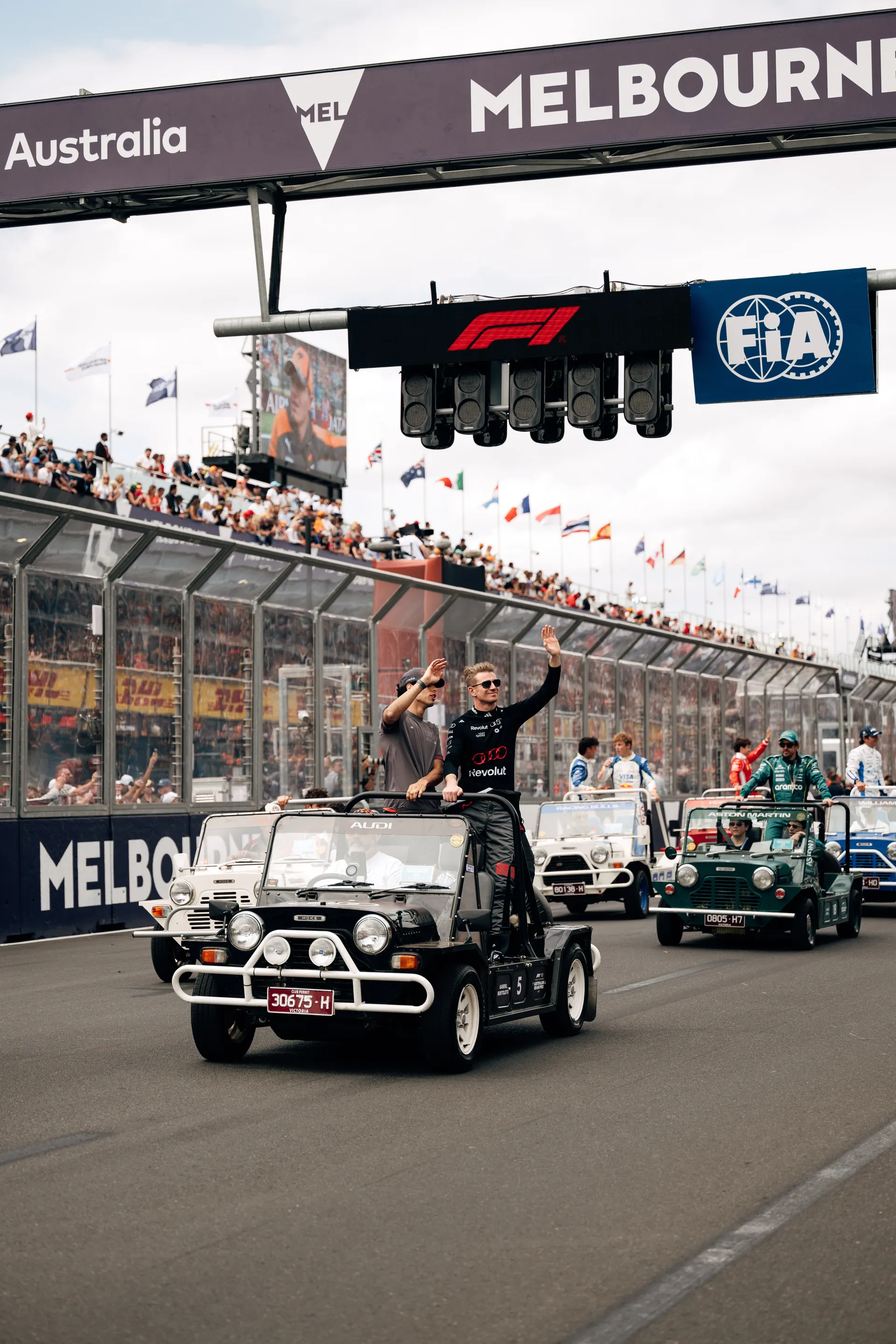 Audi Revolut F1® Team drivers Nico Hulkenberg and Gabriel Bortoleto wave to the crowd from a parade vehicle during the Melbourne drivers parade.