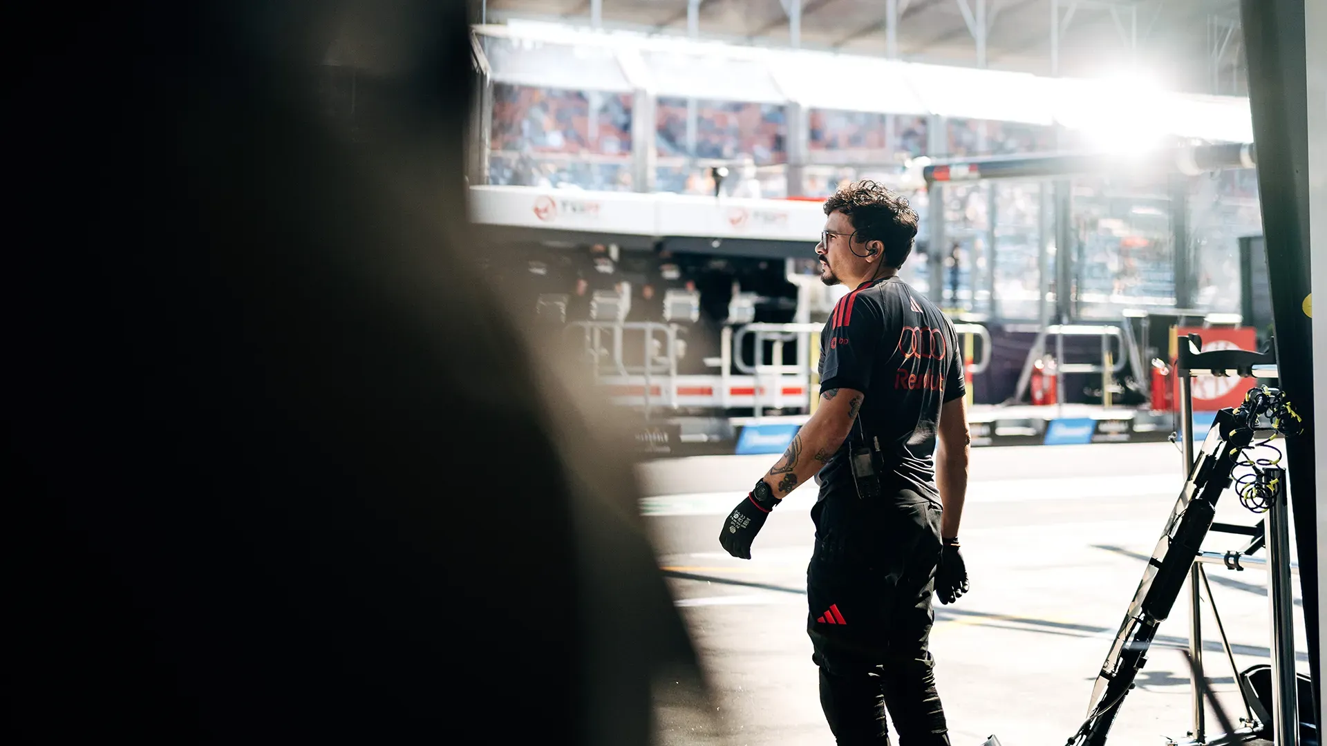 A mechanic standing in front of the pit looking at the pitane