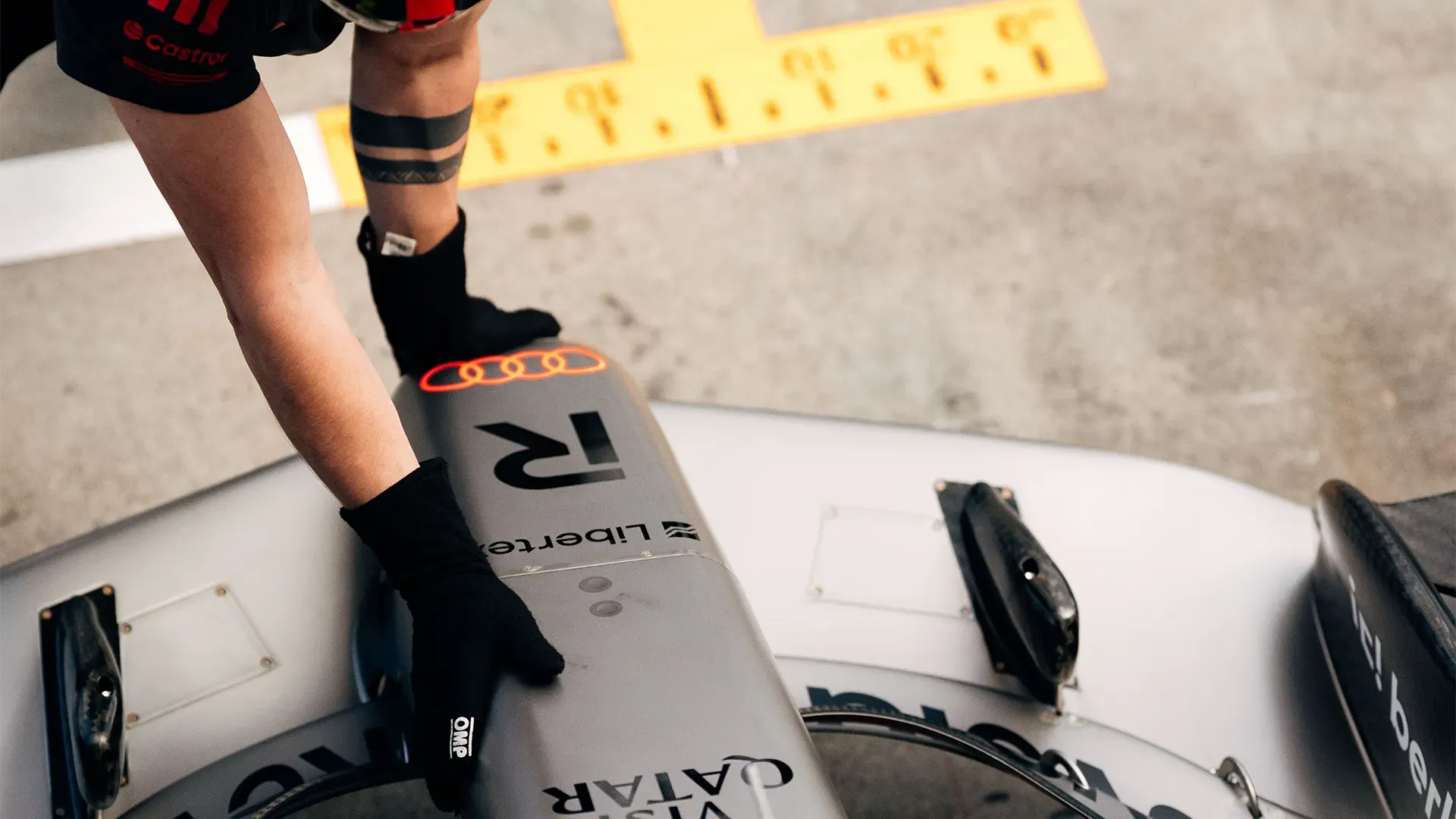 A mechanic grabbing the nose of the car