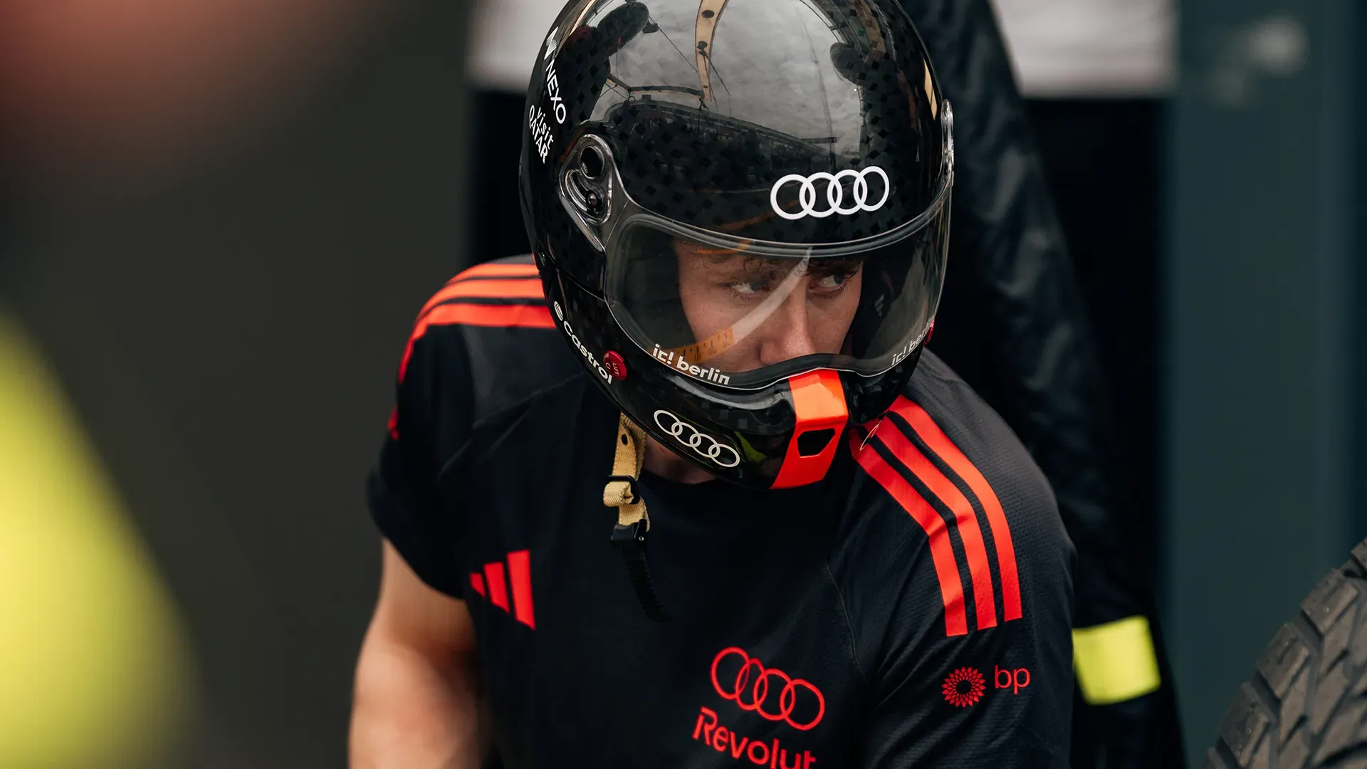 A pit crew member is looking concentrated to the incoming car