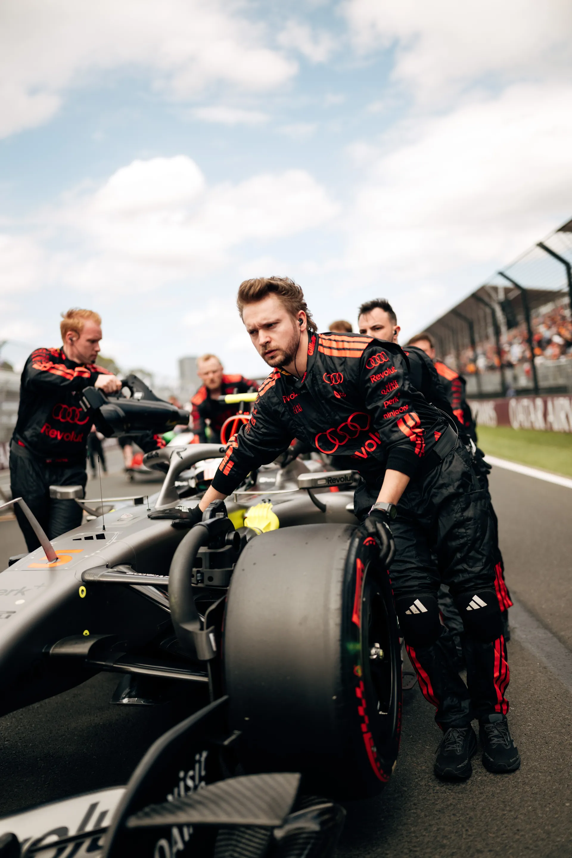 Audi Revolut F1® Team mechanics push the Formula 1 car into position on the Melbourne grid before the race.