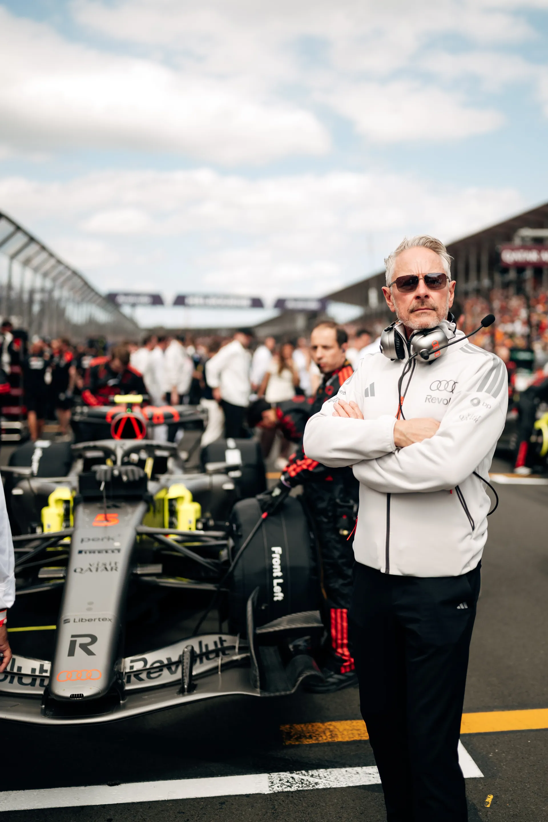 Audi Revolut F1® Team representative stands with arms folded in front of the car on the Melbourne grid.