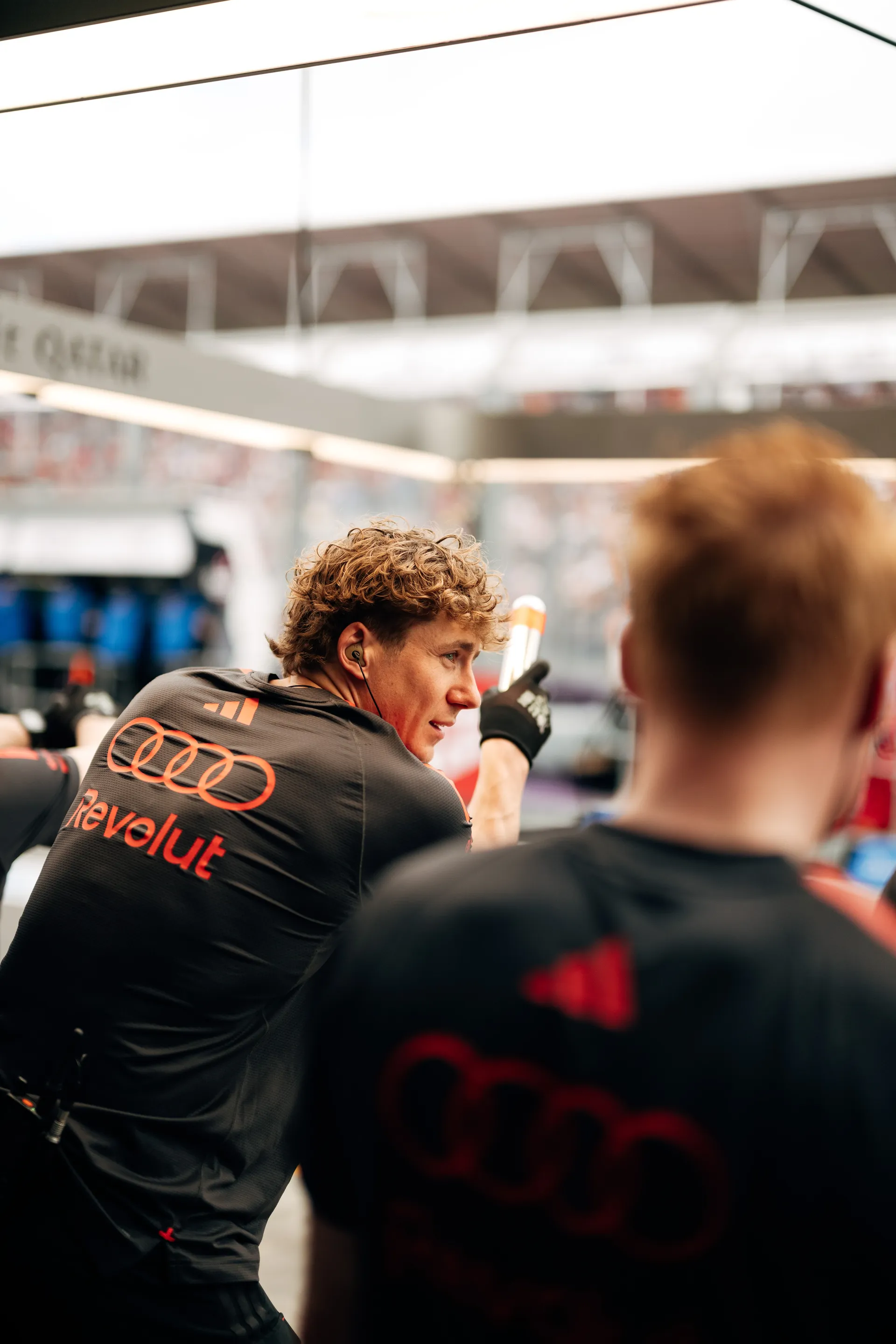Audi Revolut F1® Team crew member turns back and gestures while speaking inside the garage during qualifying.