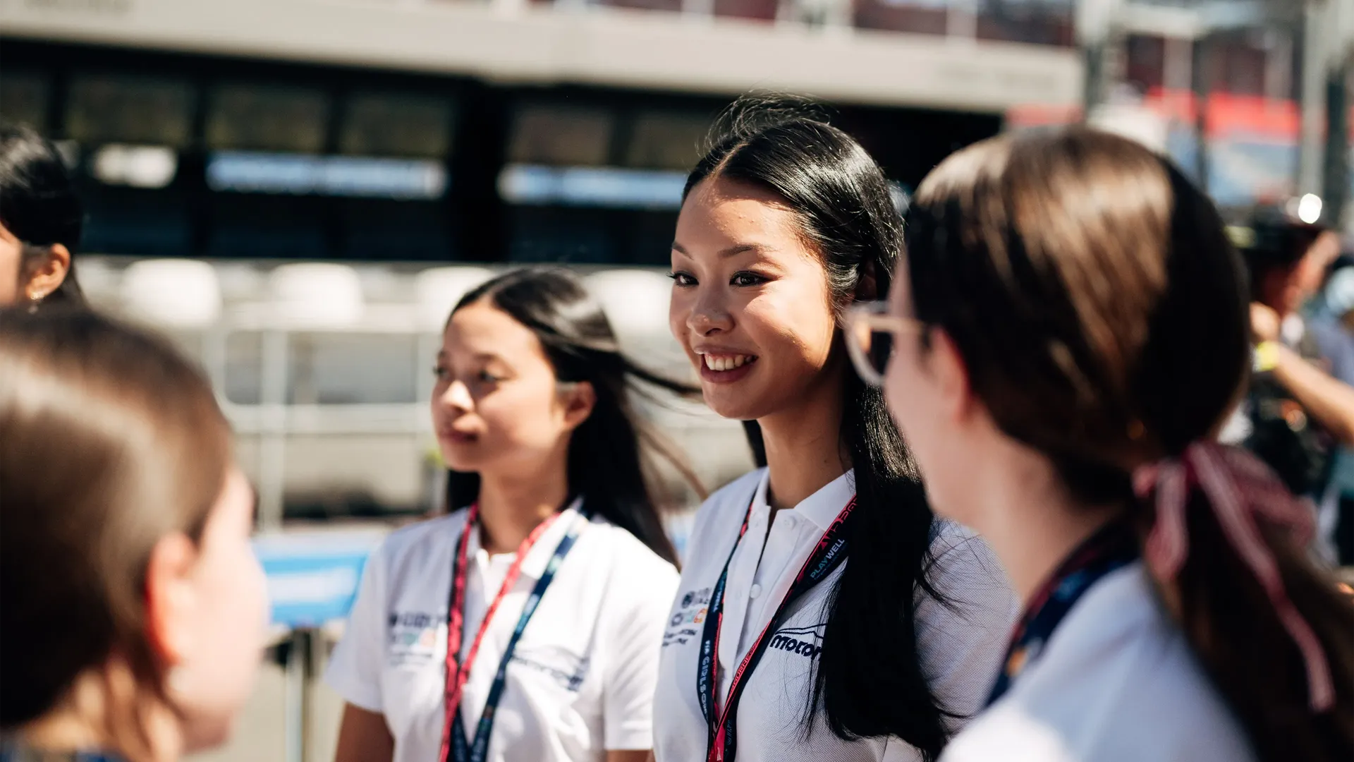 A close-up photo of a girl standing in the group of others
