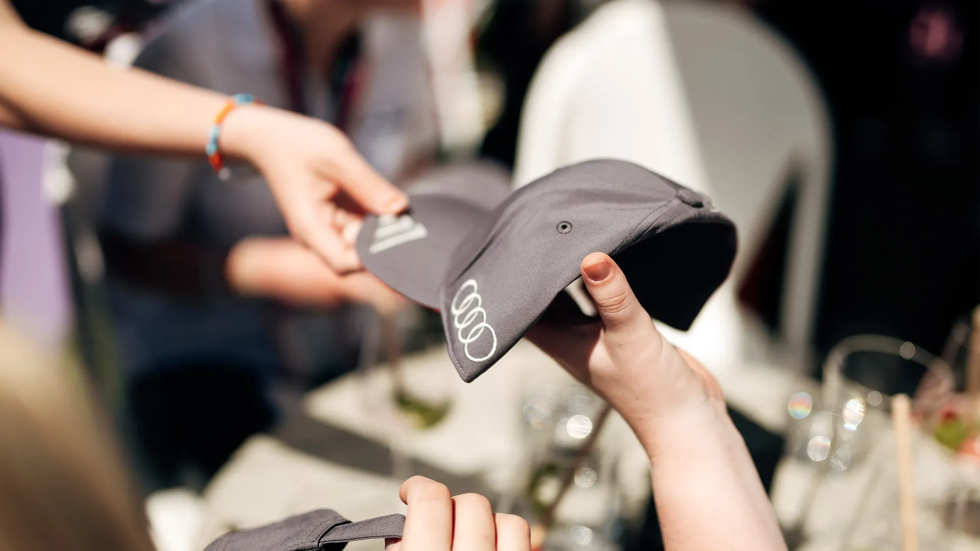 A team member giving merchandise caps to the girls