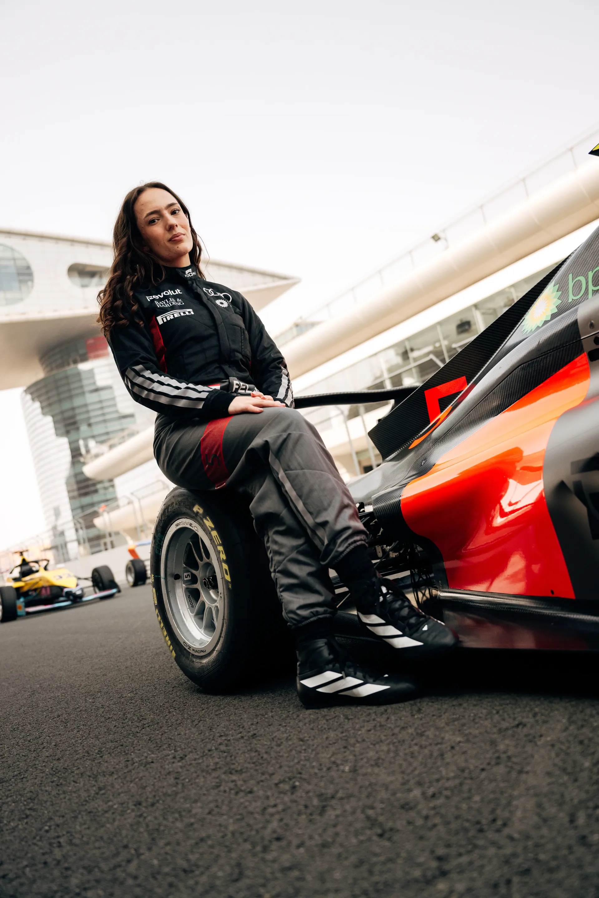  Emma Felbermayr sitting on the back wheel of the Audi Revolut F1® Team Academy car number 5 on the race track