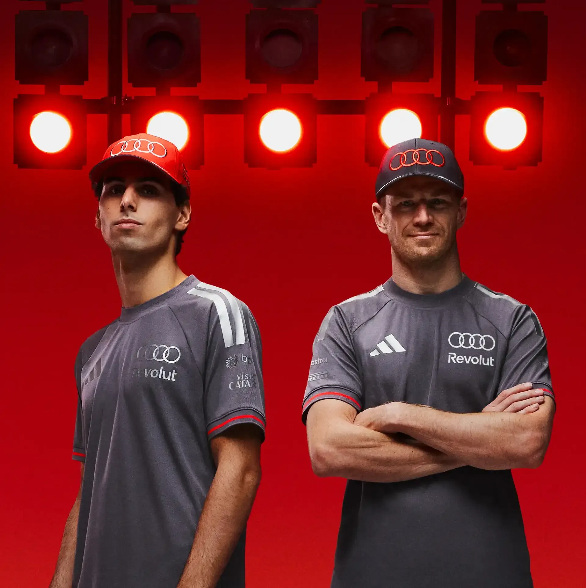 Audi Revolut F1® Team driver side by side, wearing crew members caps and tshirts,  Gabriel Bortoleto and Nico Hulkenberg, authentic tshirts, grey with chalk audi rings Logo and Adidas Logo, in the Studio