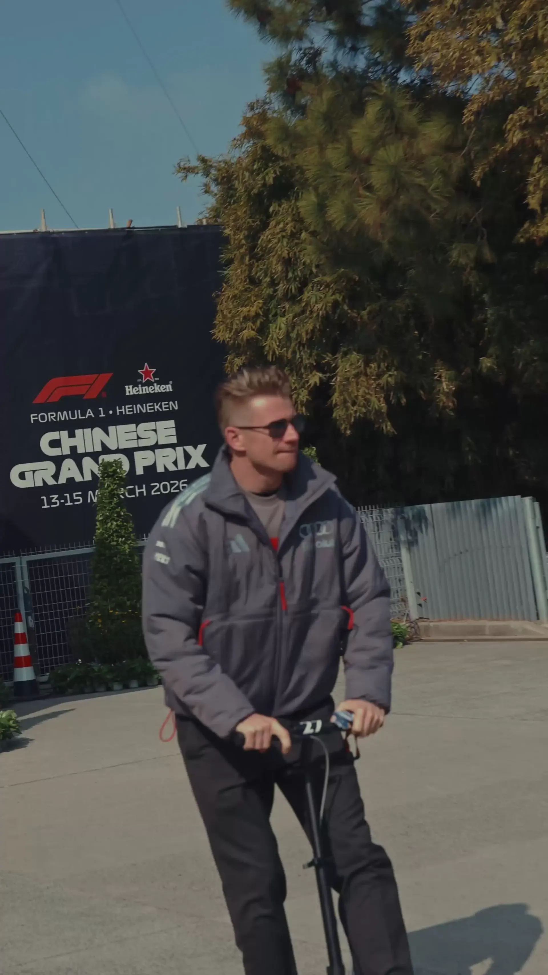 Nico Hulkenberg driving a scooter at the Audi Revolut F1® Team Chinese GP at Shanghai racetrack