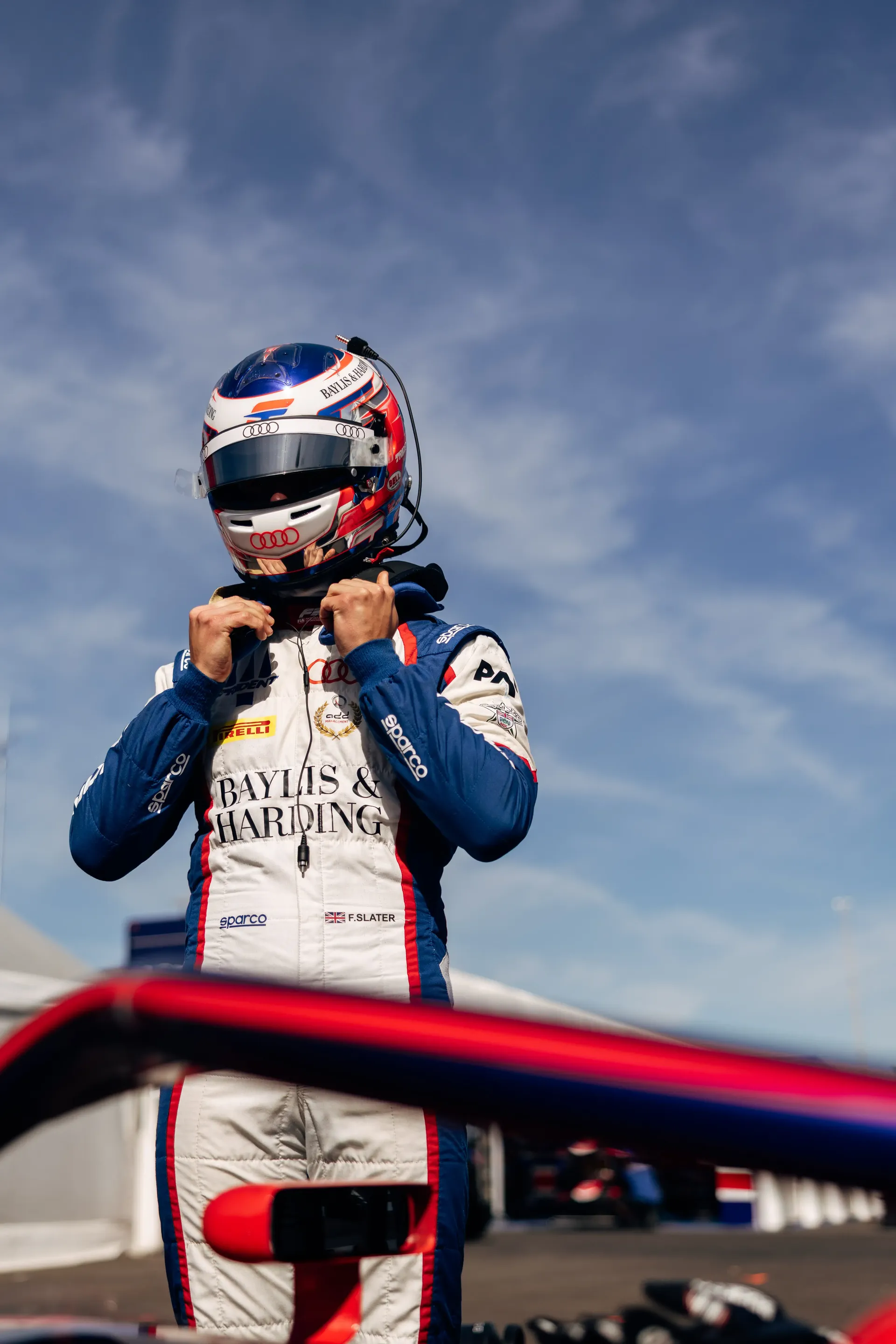 Audi Revolut F1® Team Academy driver Freddie Slater fastens his helmet while preparing for an FIA Formula 3 session at the Hungaroring.