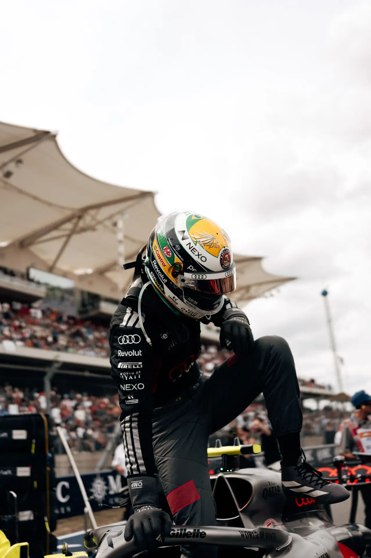 Gabriel Bortoleto of the Audi Revolut F1® Team in a black race suit and helmet climbing out of the car on the grid in Austin