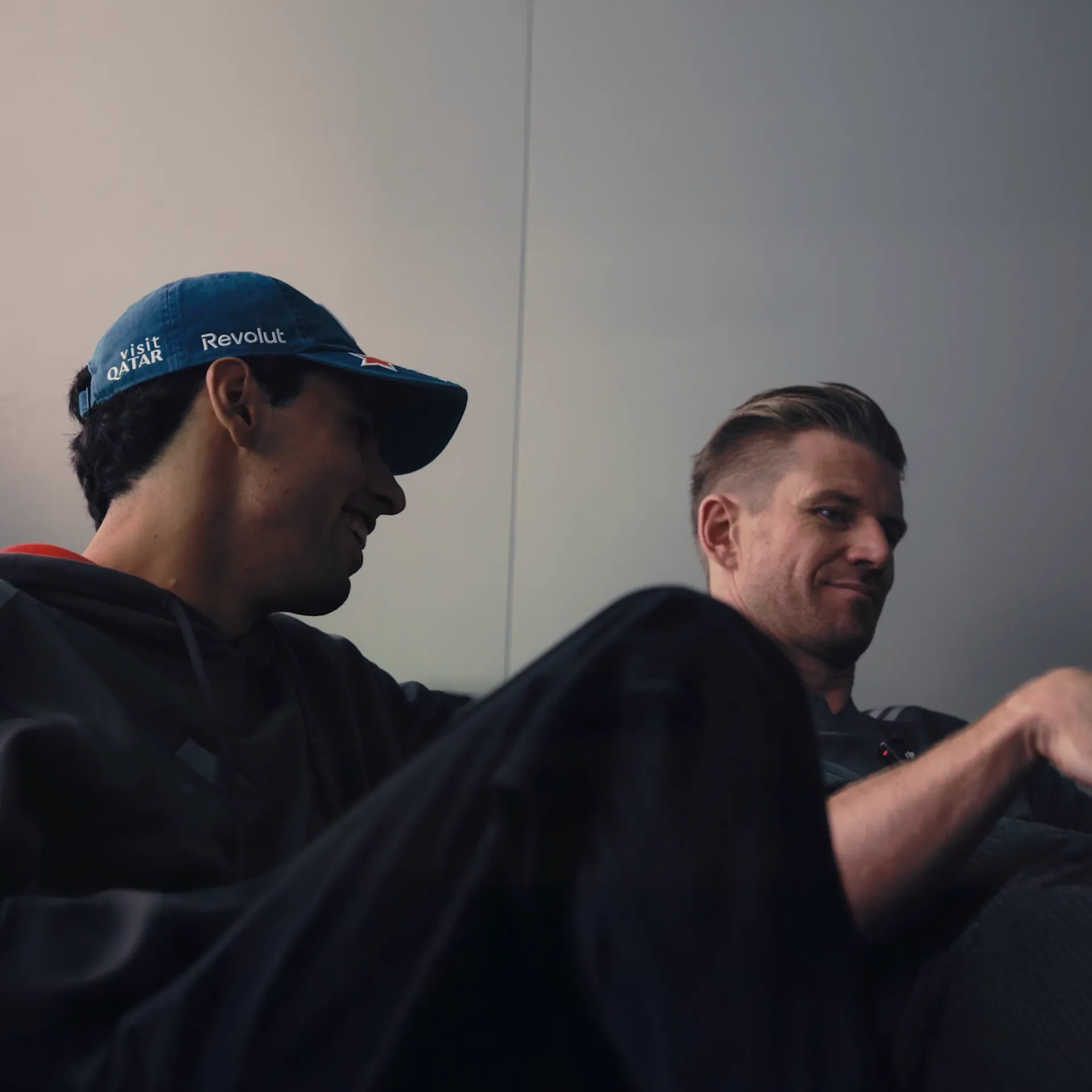 Gabriel Bortoleto and Nico Hulkenberg of the Audi Revolut F1® Team sit together in Austin, Bortoleto in a blue Revolut cap