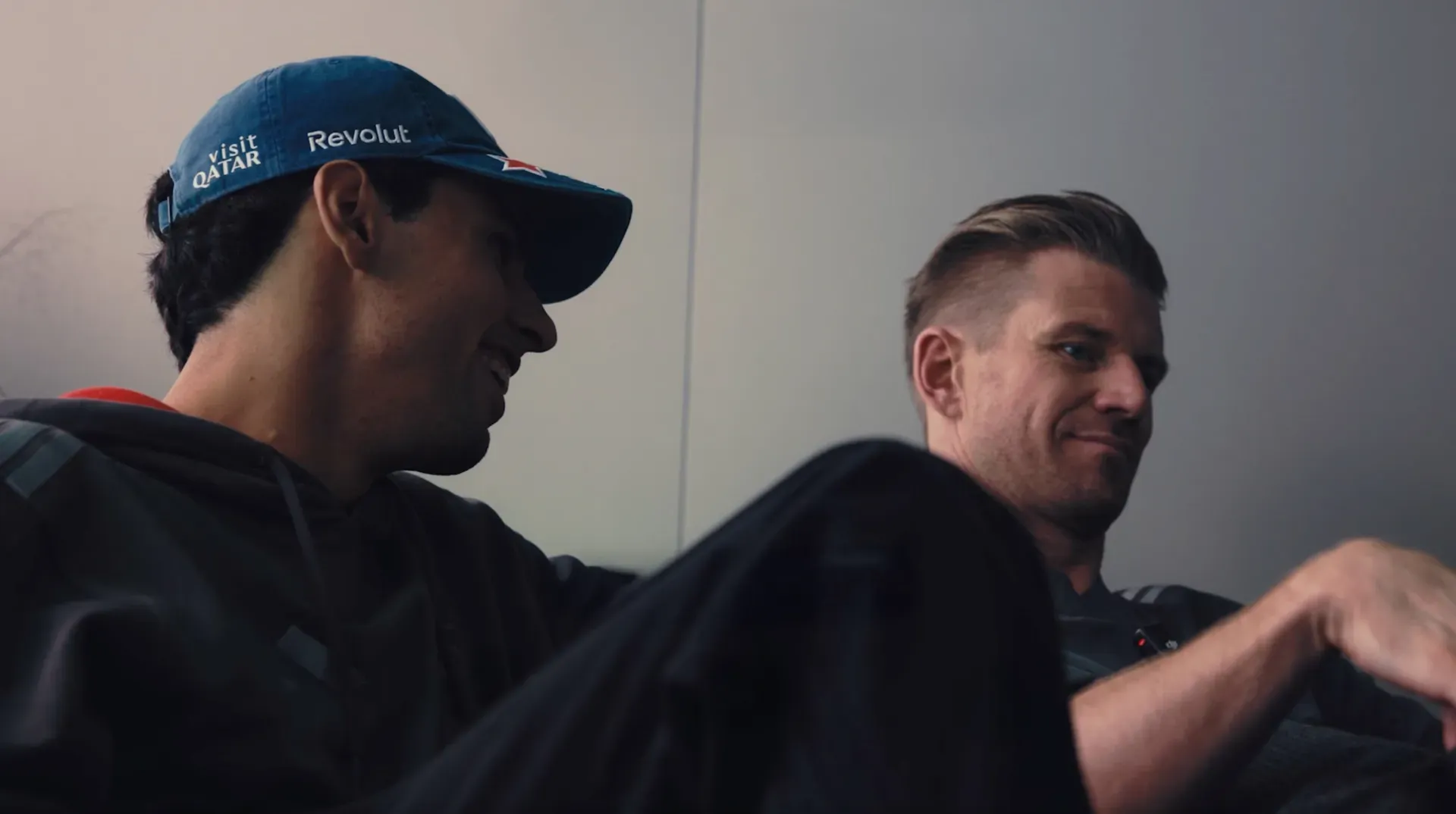 Gabriel Bortoleto and Nico Hulkenberg of the Audi Revolut F1® Team sit together in Austin, Bortoleto in a blue Revolut cap