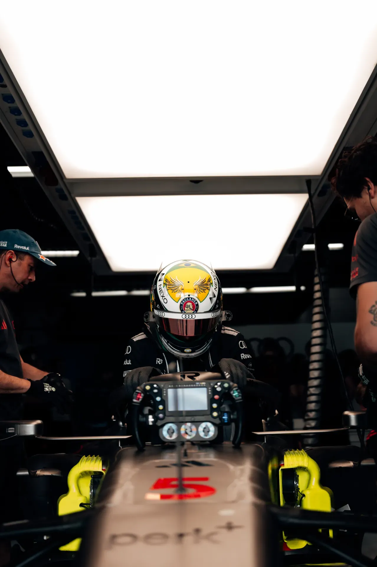 Driver in a helmet sits in car number 5 of the Audi Revolut F1® Team in the garage in Austin