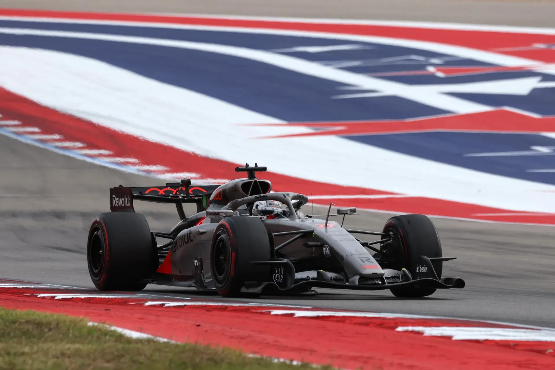 Car of the Audi Revolut F1® Team driving through a corner past red, white and blue track markings in Austin