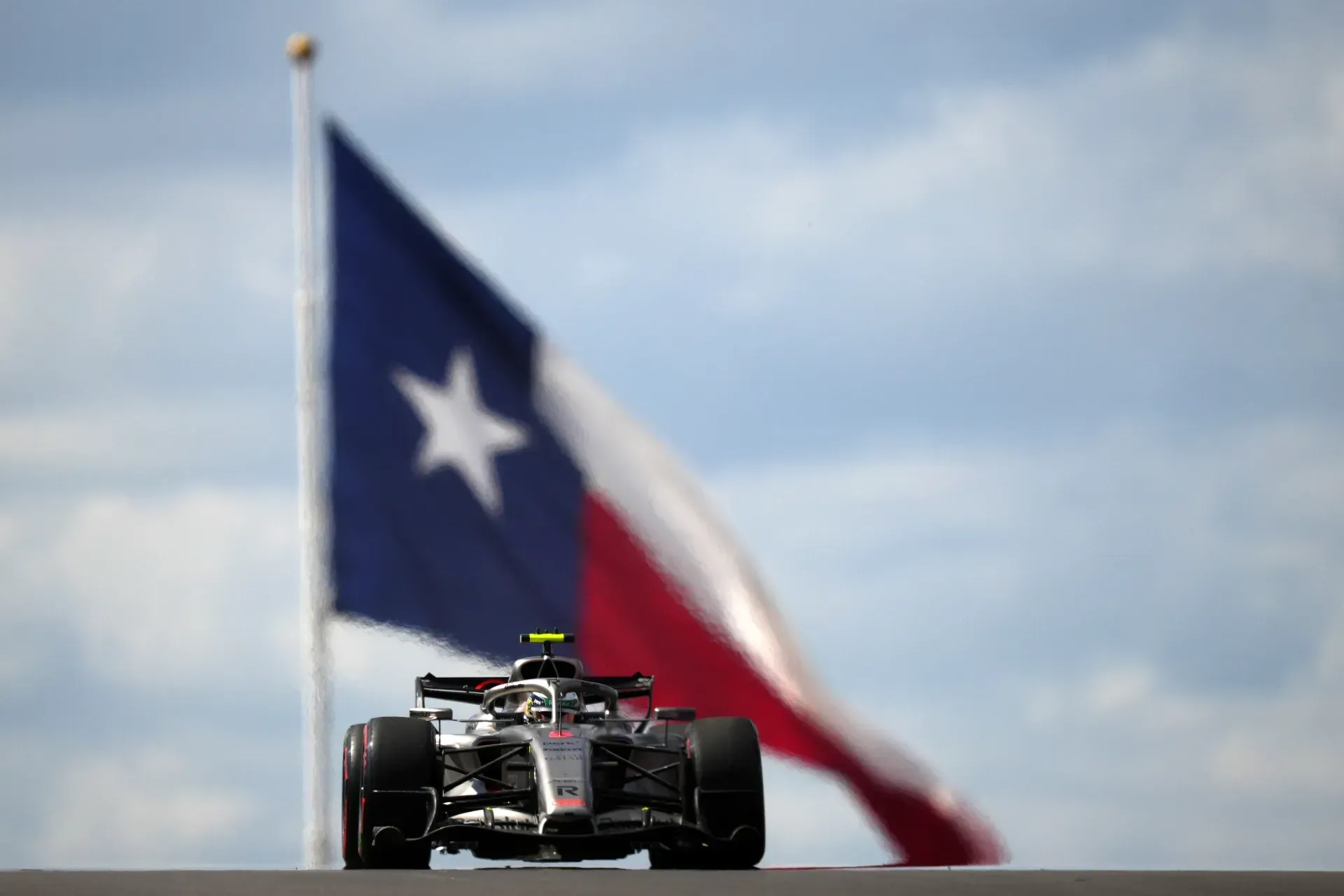Car of the Audi Revolut F1® Team approaching head-on in front of a large Texas flag in Austin