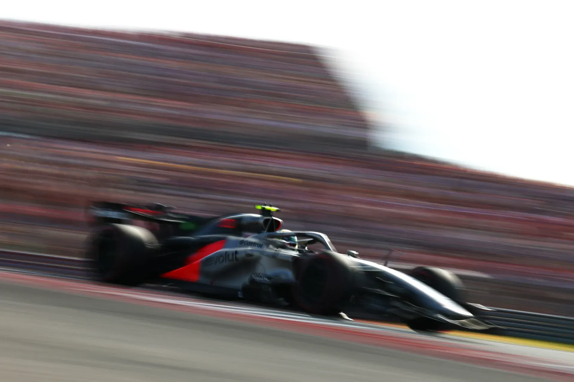 Car of the Audi Revolut F1® Team passing blurred grandstands at speed in the United States Grand Prix in Austin
