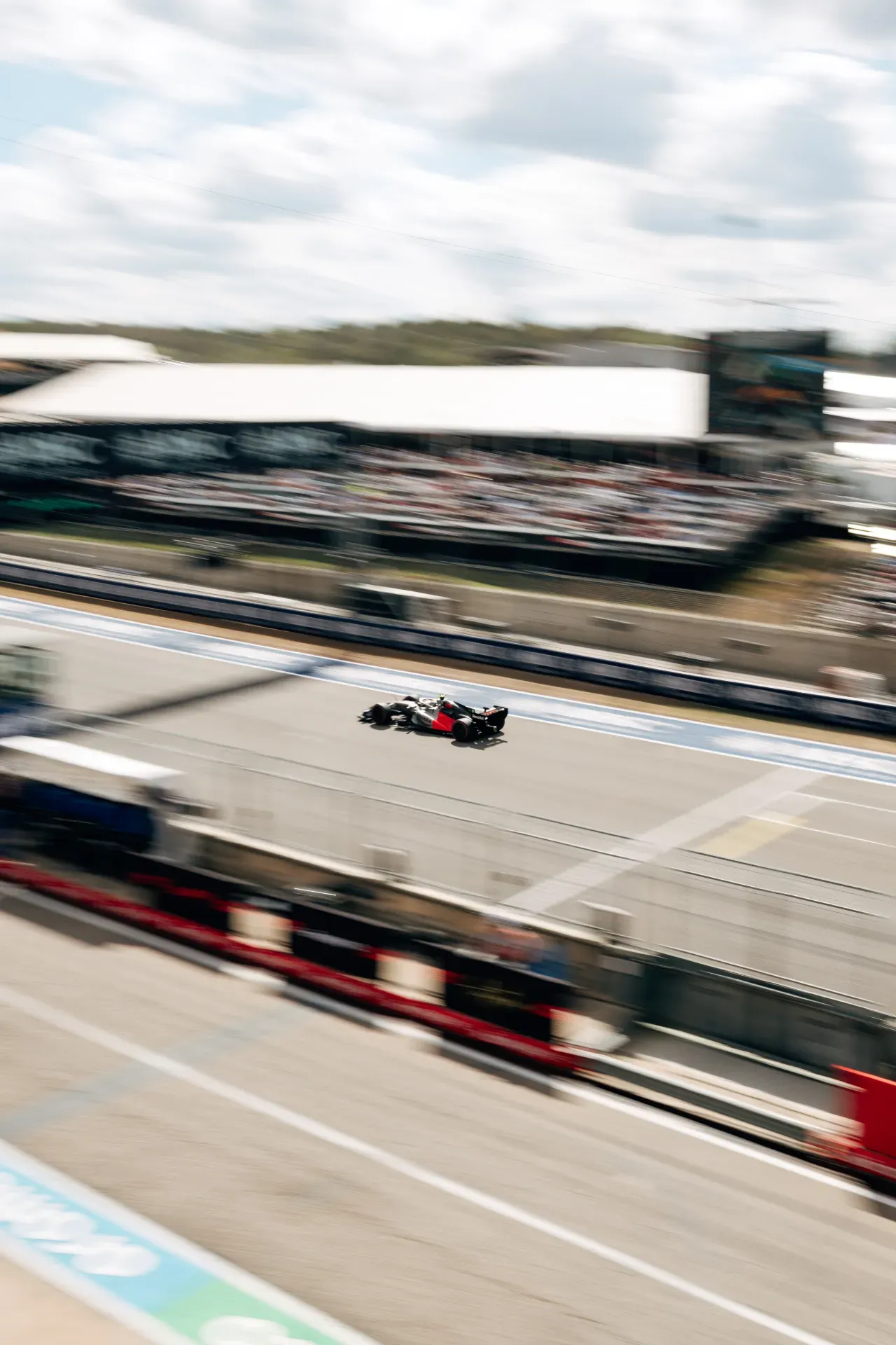 Race car of the Audi Revolut F1® Team passes the pit wall and grandstand in a motion-blurred shot in Austin