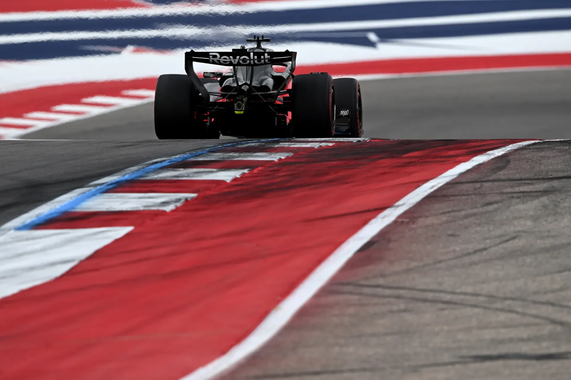 Car of the Audi Revolut F1® Team driving through a corner past red, white and blue track markings in Austin