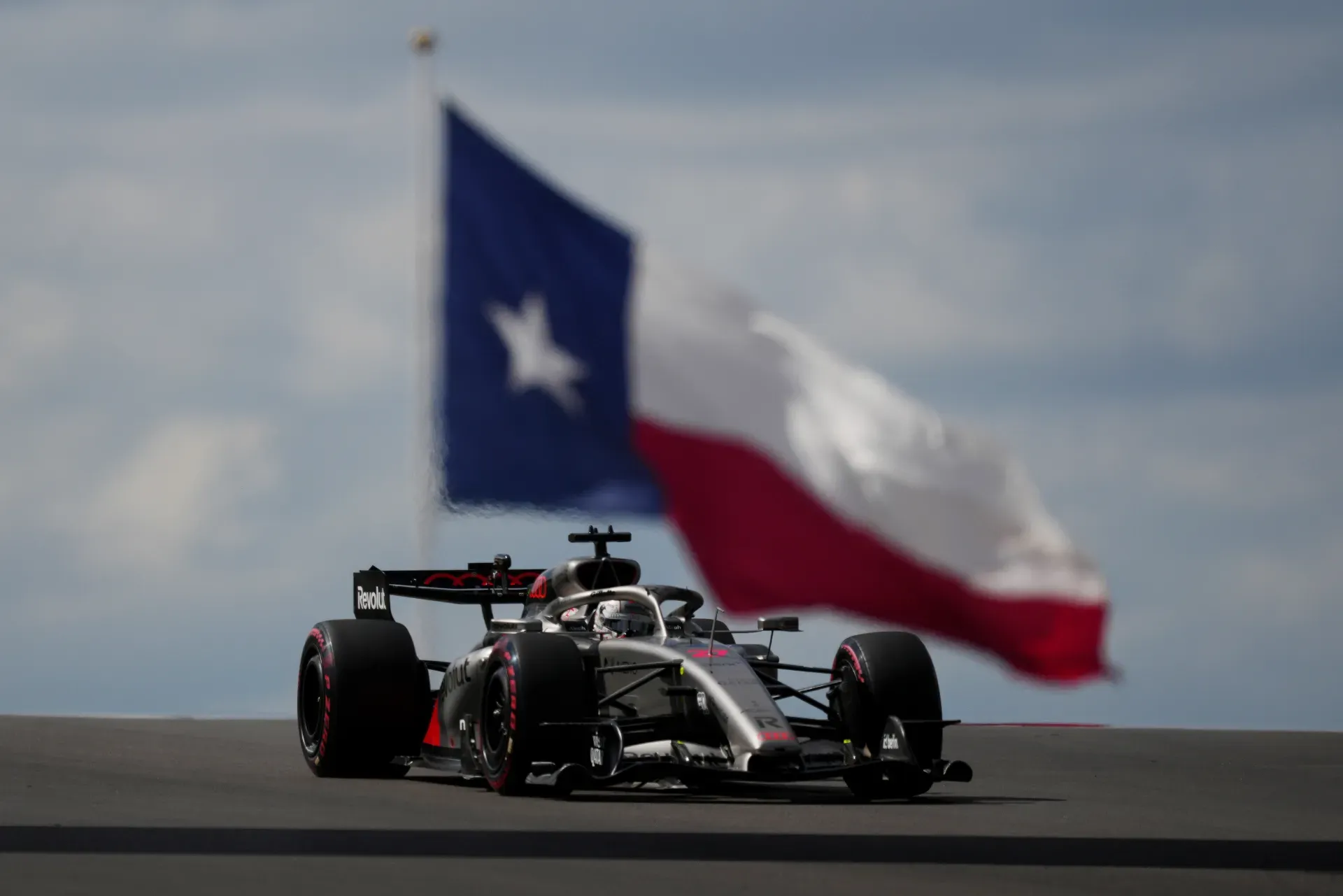 Car of the Audi Revolut F1® Team approaching head-on in front of a large Texas flag in Austin