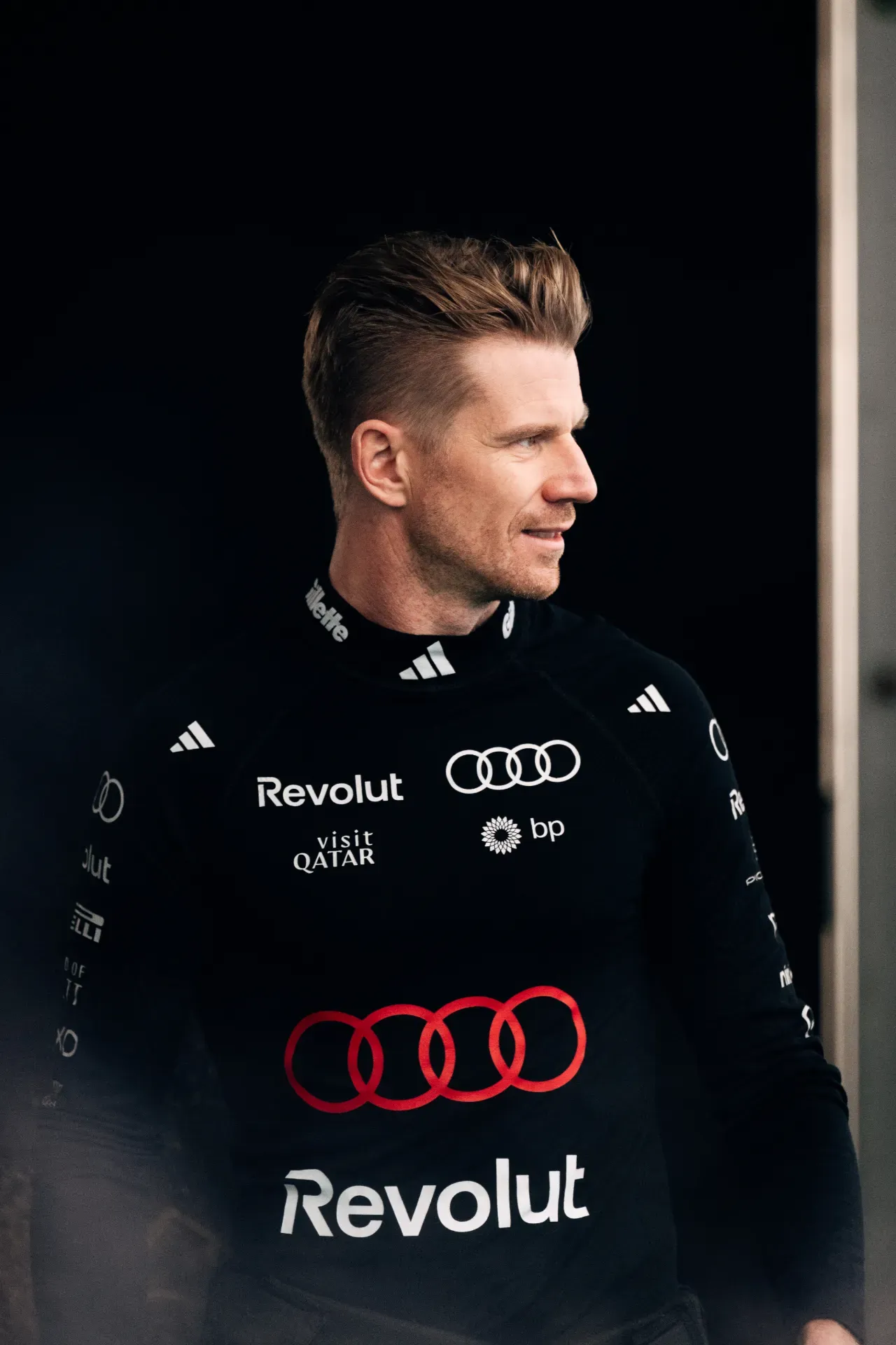 Nico Hulkenberg of the Audi Revolut F1® Team in a black team top with sponsor logos, looking to the right in Austin