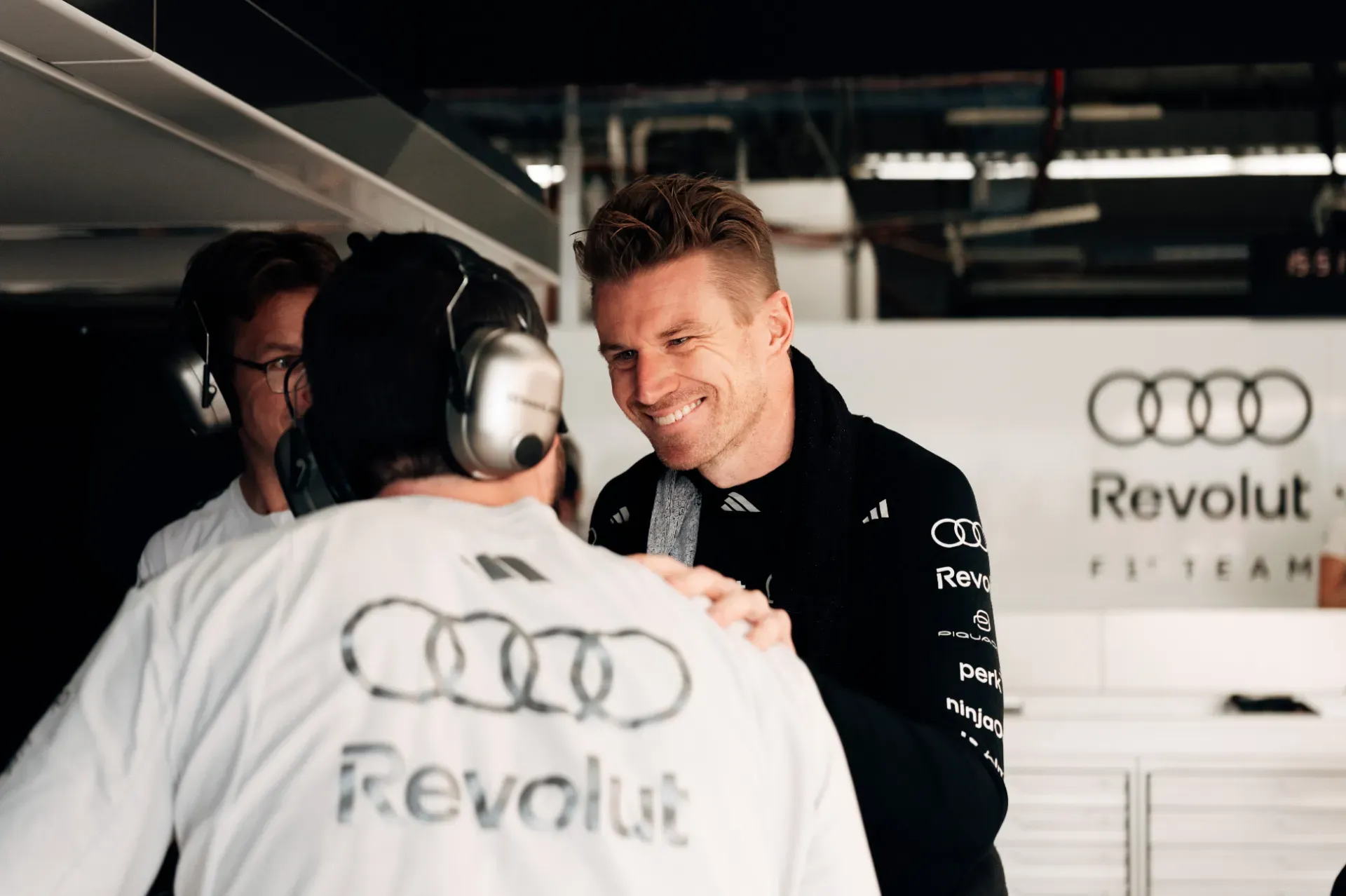 Nico Hulkenberg of the Audi Revolut F1® Team greets a mechanic in the garage in Austin