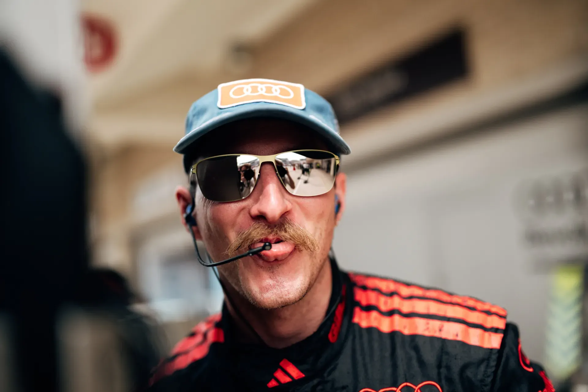 Team member of the Audi Revolut F1® Team in a black and red race suit, cap, sunglasses and headset in Austin