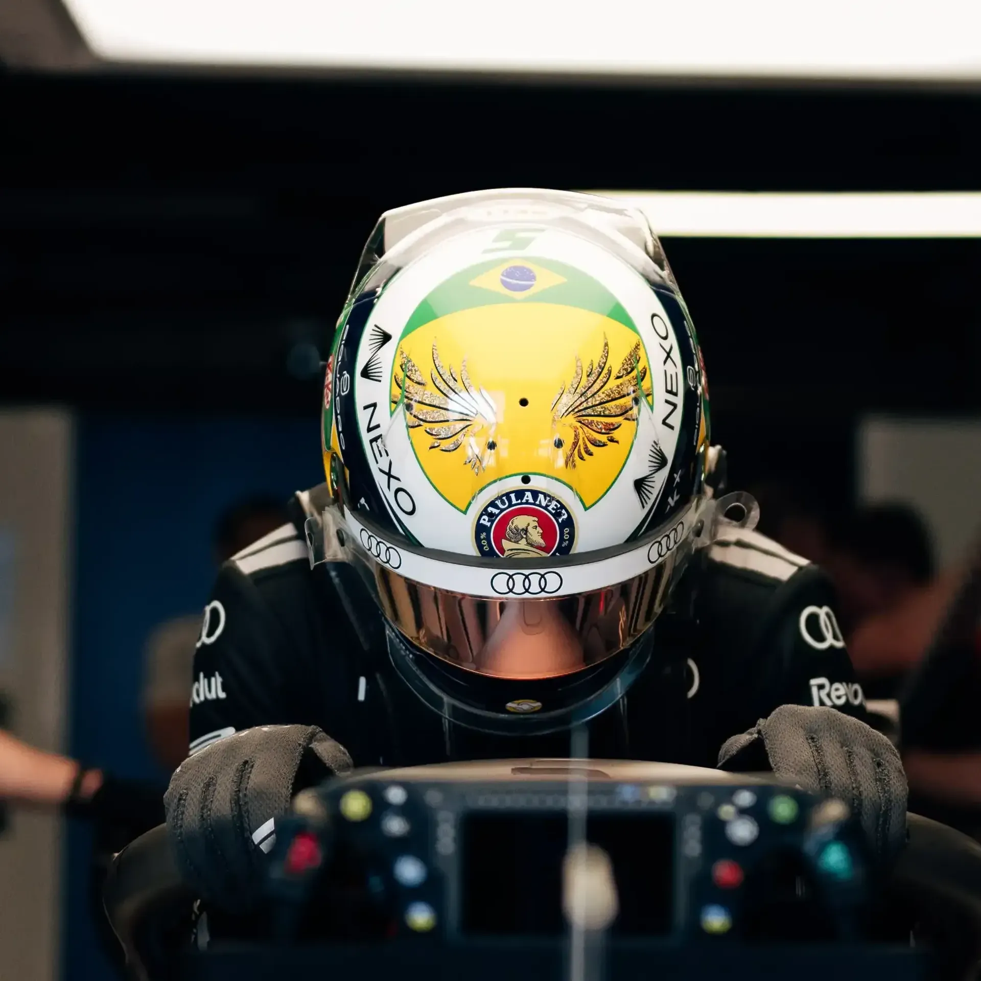 Gabriel Bortoleto driver at the Audi Revolut F1® Team inside the garage surrounded by team mechanics jumping inot the cockpit of the Audi R26