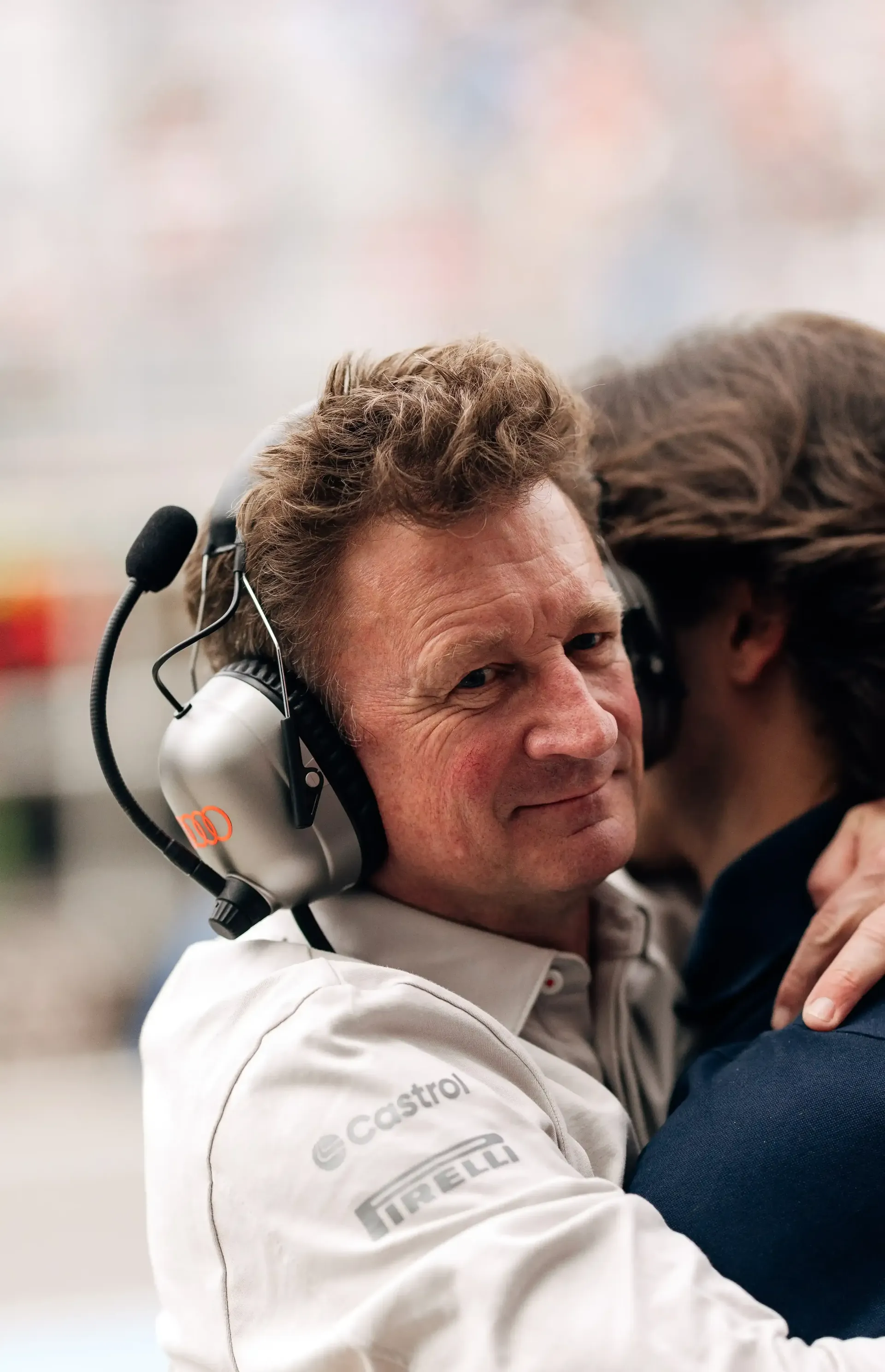 Allan McNish racing director at the Audi Revolut F1® Team hugging a crew member inside the paddock