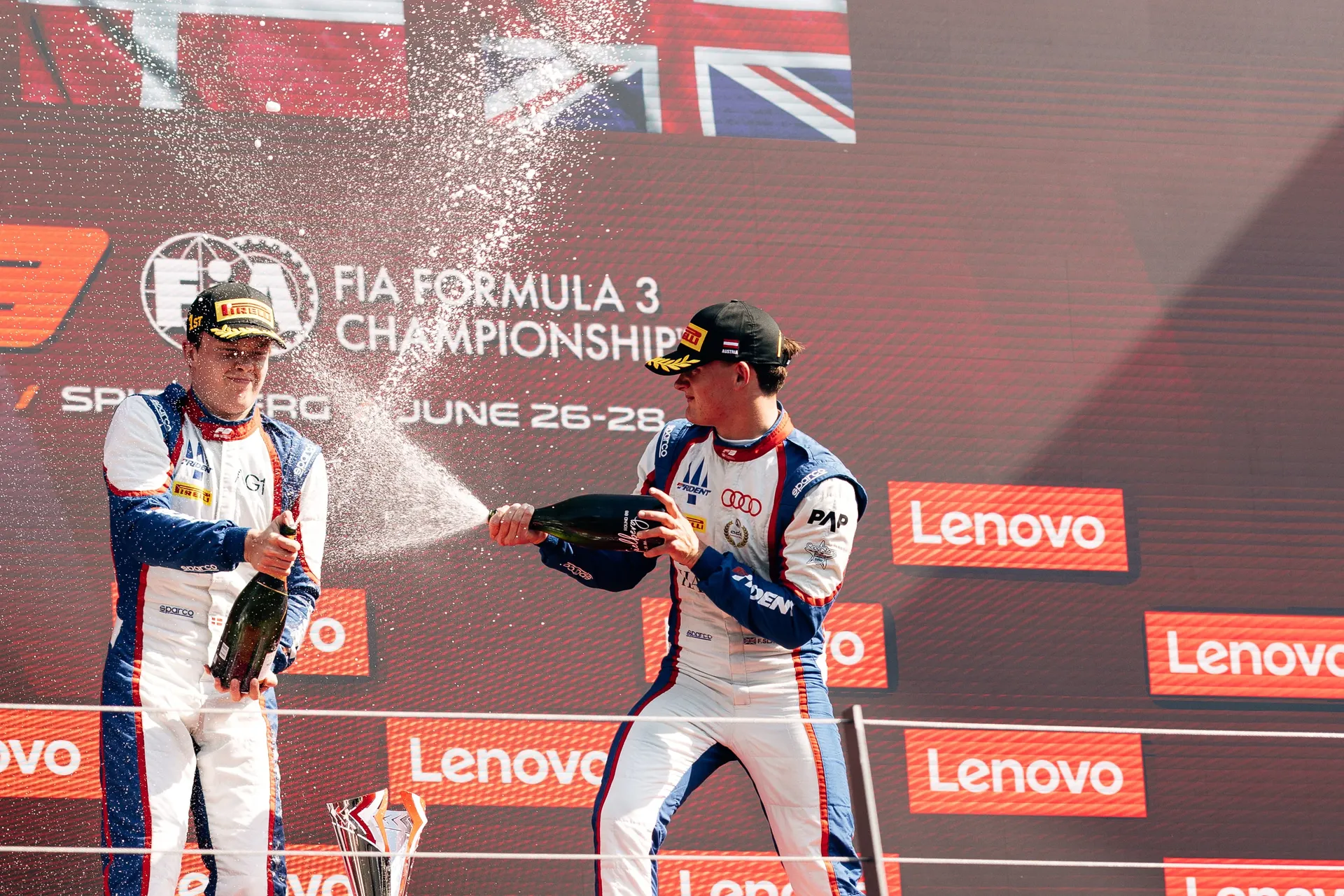 Freddie Slater and another driver spraying champagne on the podium in Spielberg