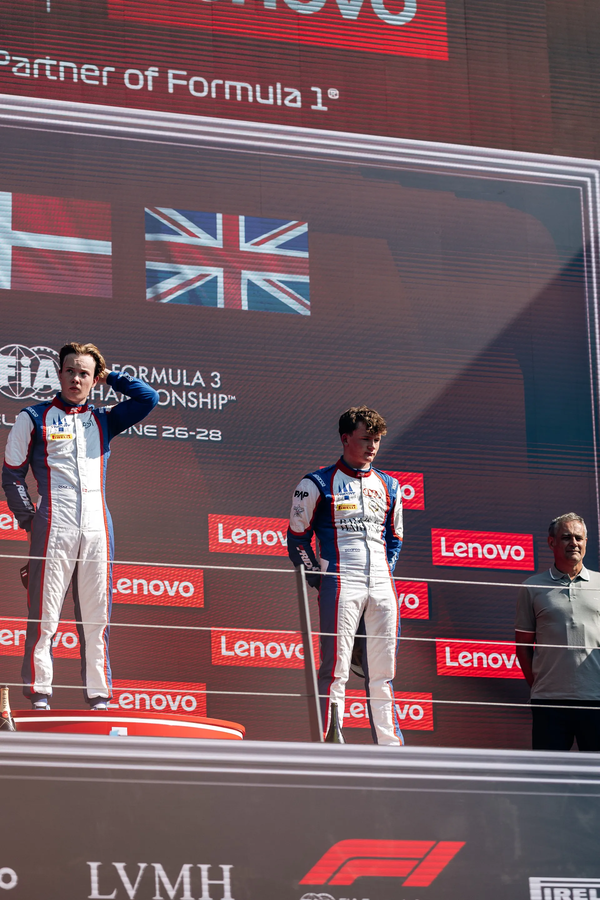 Freddie Slater standing on the podium beside another driver in Spielberg
