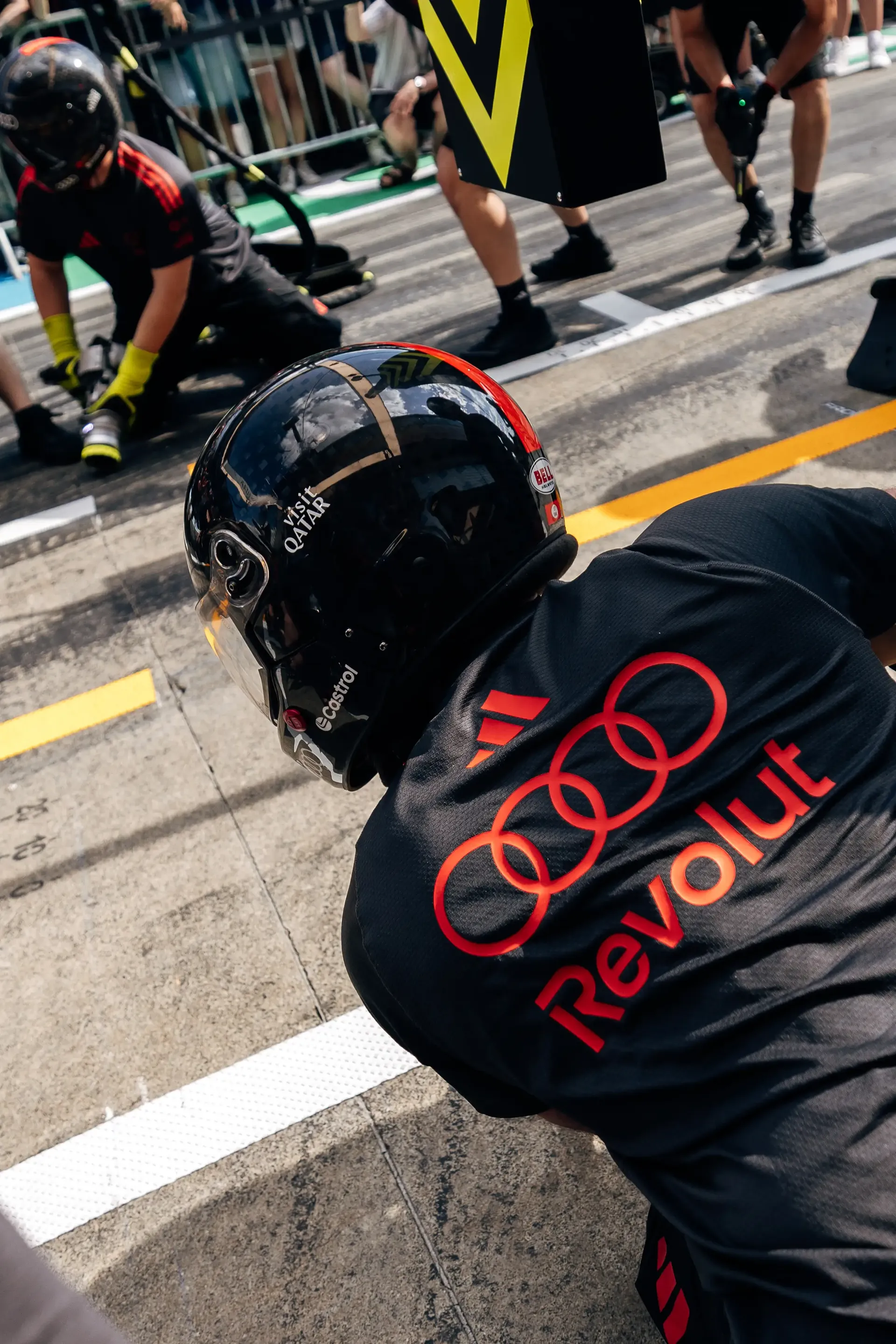 An Audi Revolut F1® Team pit stop crew member kneels in position during pit stop practice ahead of the Formula 1® Austrian Grand Prix at the Red Bull Ring.