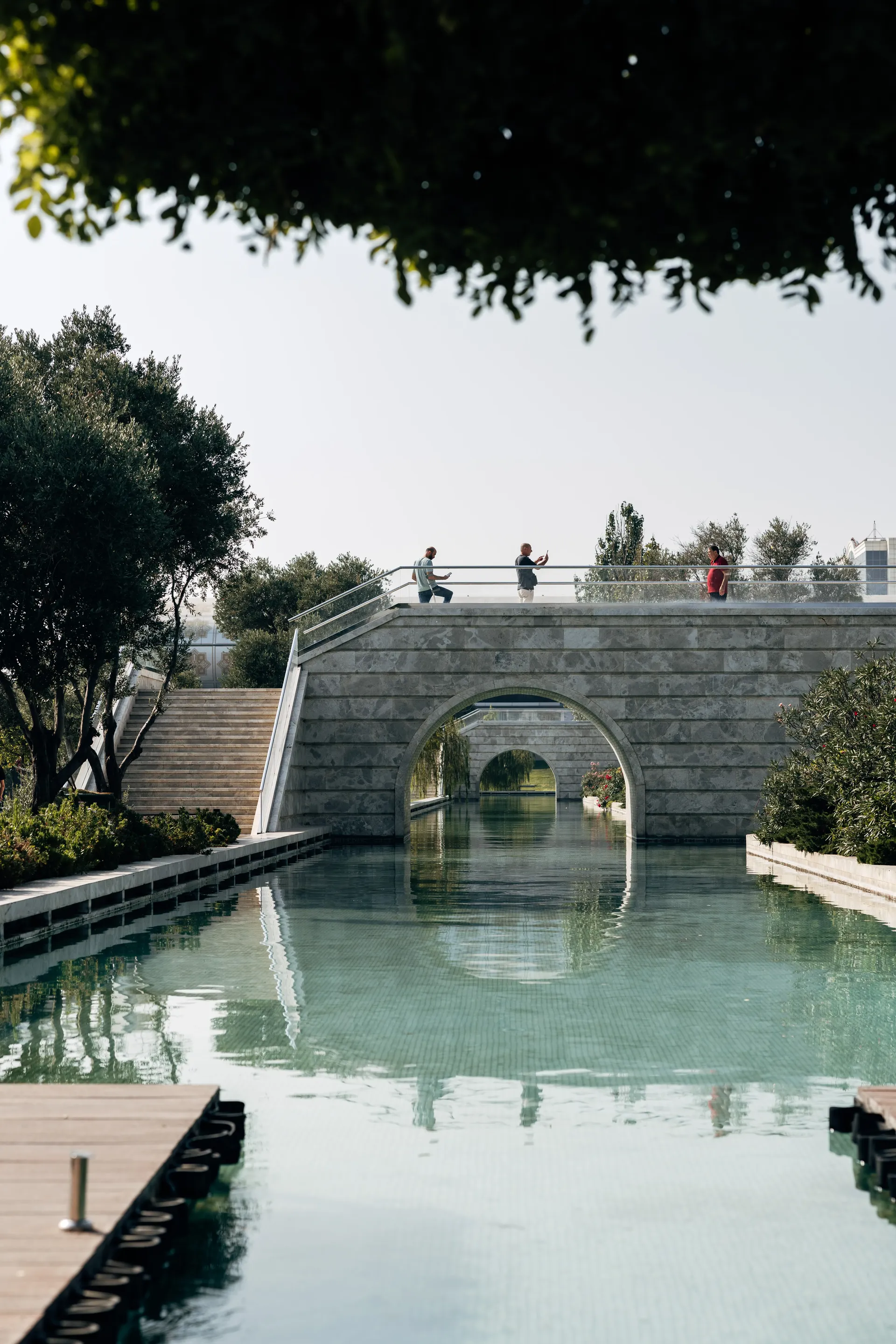 Historic stone bridge and reflecting pool in a Baku park