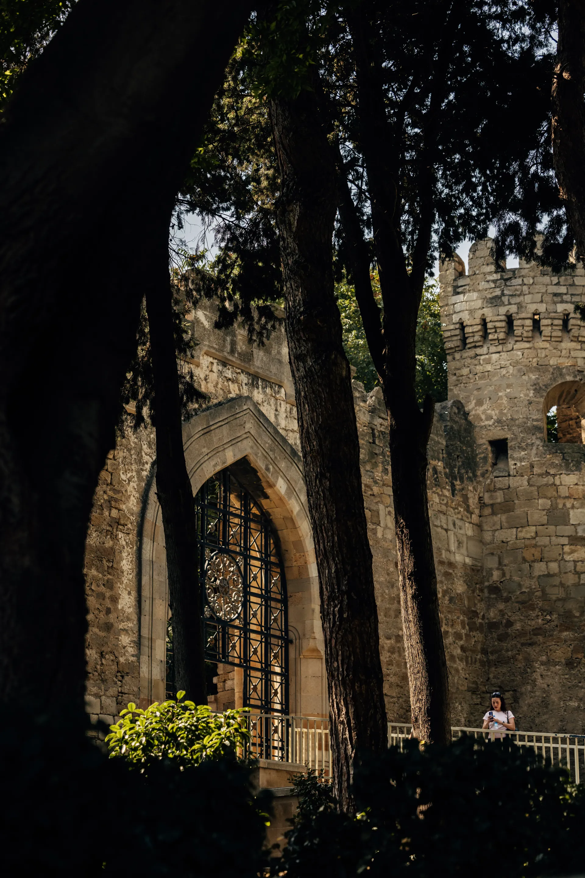 Historic stone gateway surrounded by trees in Baku, Azerbaijan