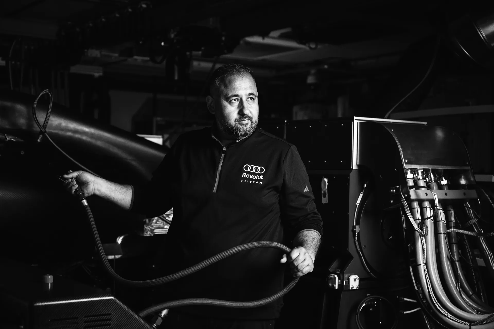 Hakan operating the powertrain test bench, handling cables and monitoring systems that simulate race conditions to ensure performance reliability.