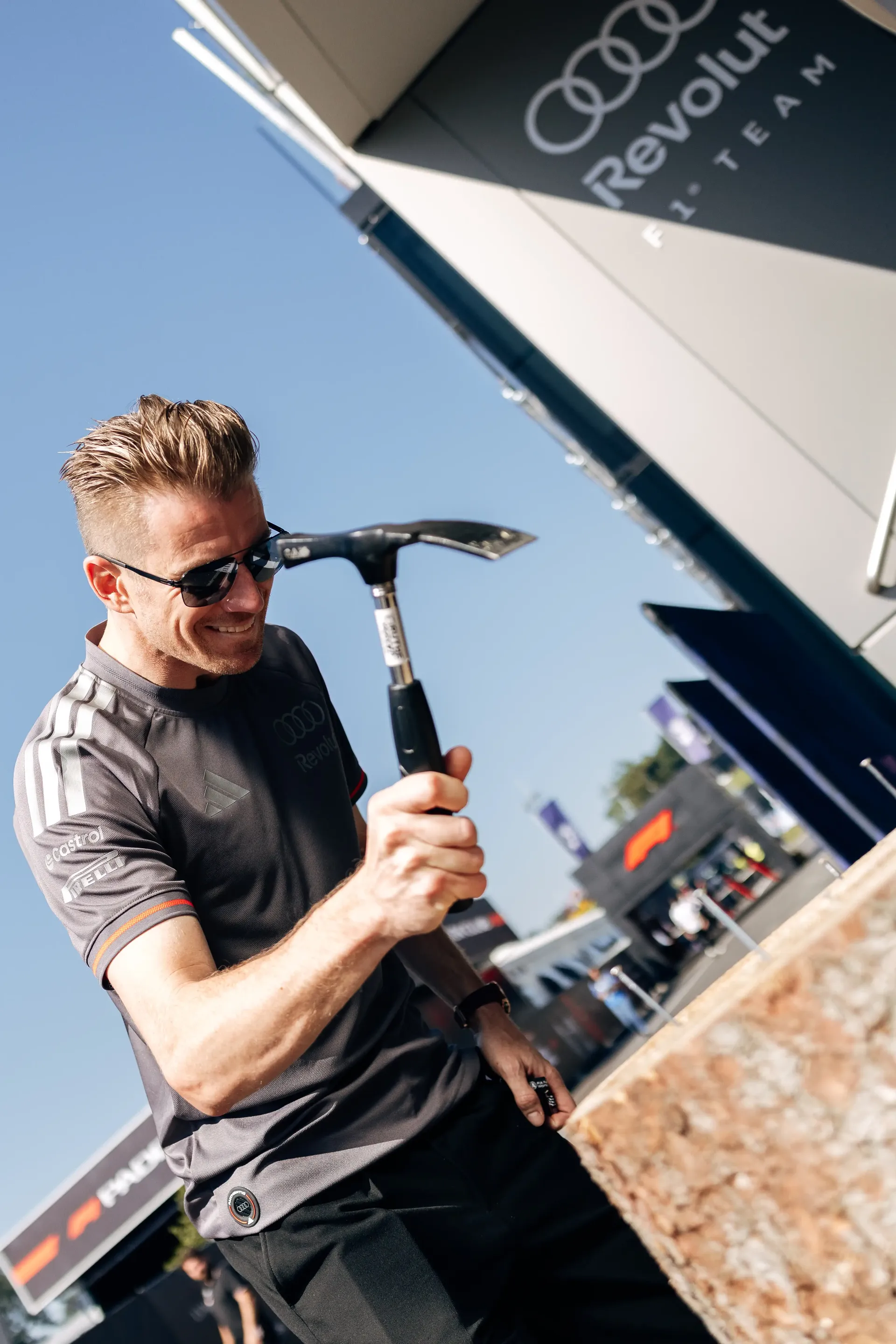 Nico Hulkenberg playfully poses with a hammer in the Spielberg paddock ahead of FP3 at the Formula 1® Austrian Grand Prix at the Red Bull Ring, representing Audi Revolut F1® Team.