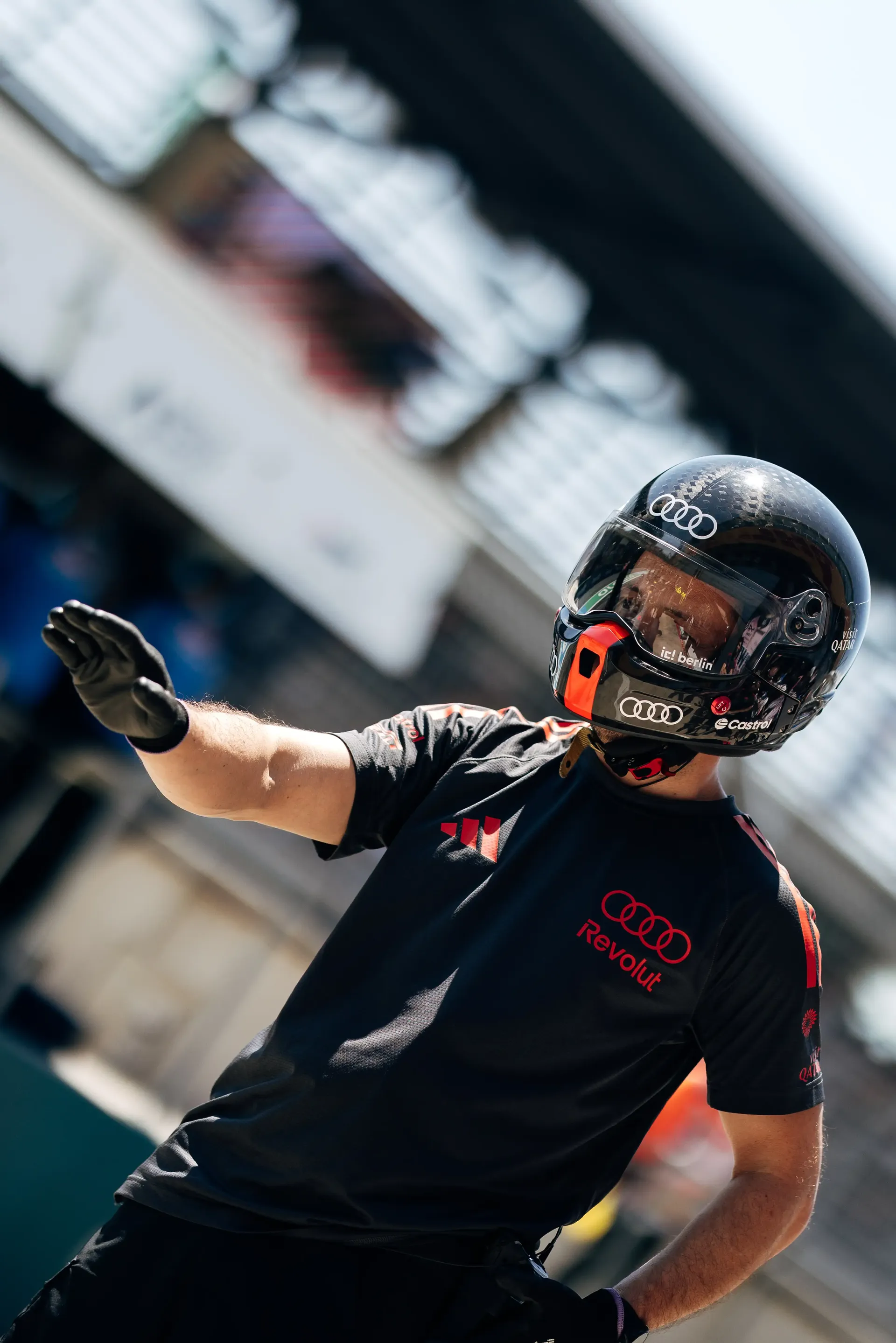 An Audi Revolut F1® Team mechanic wearing a black helmet signals in the pit lane during FP3 at the Austrian Grand Prix in Spielberg, Austria.