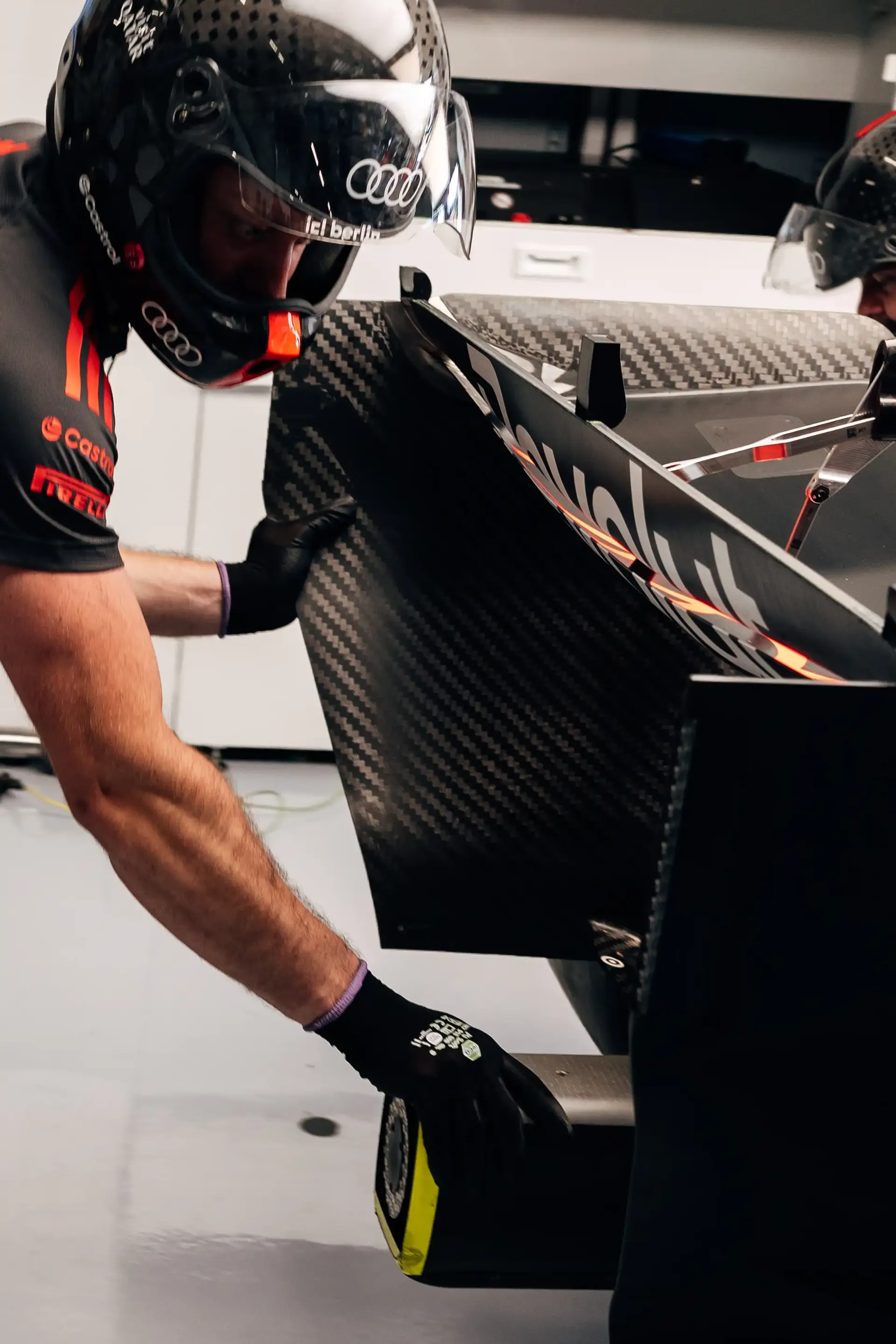 Audi Revolut F1® Team mechanic carrying a bodywork component inside the garage during FP3 at the Austrian Grand Prix in Spielberg.